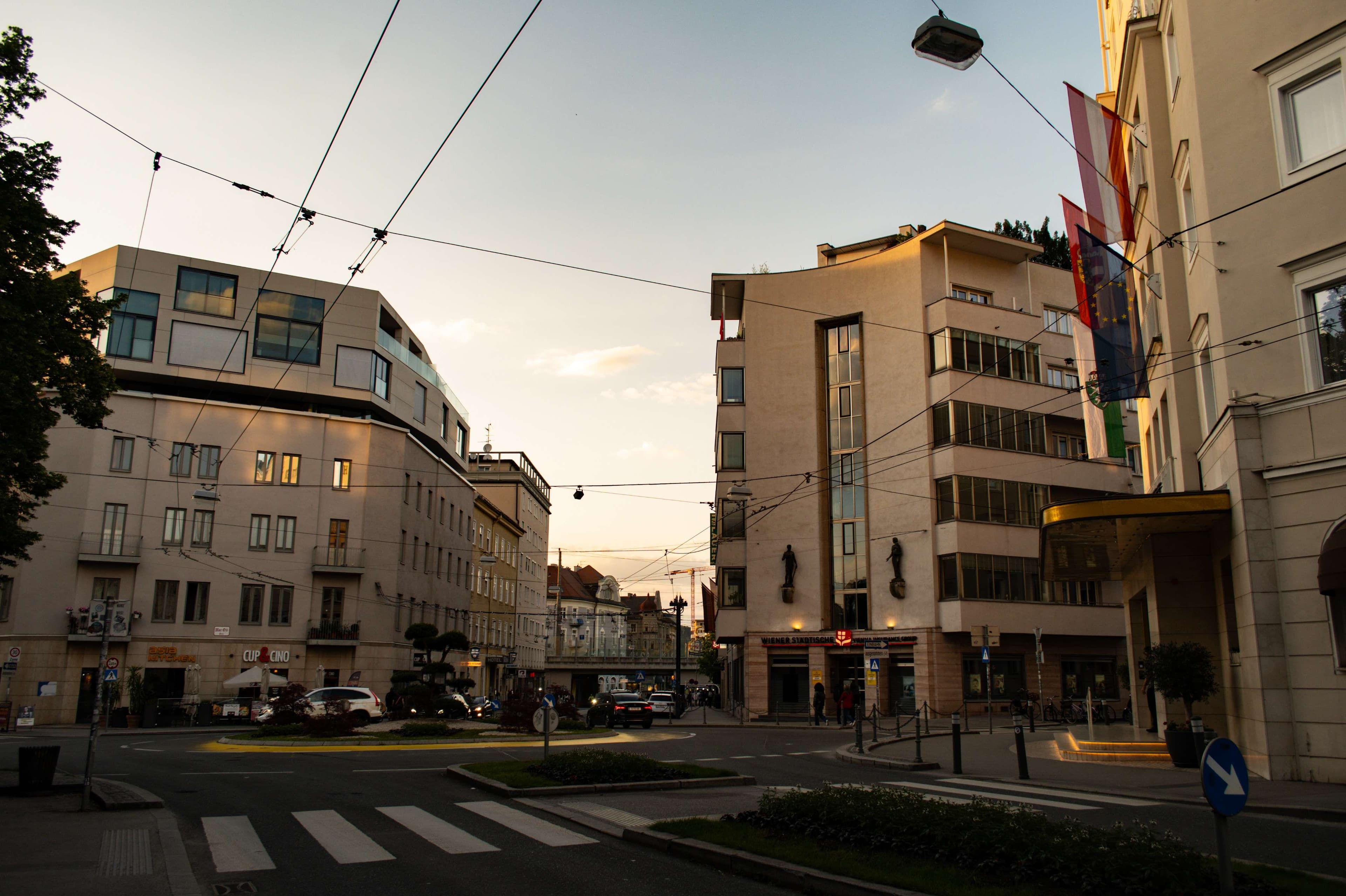 There is a street with cars and buildings on both sides.