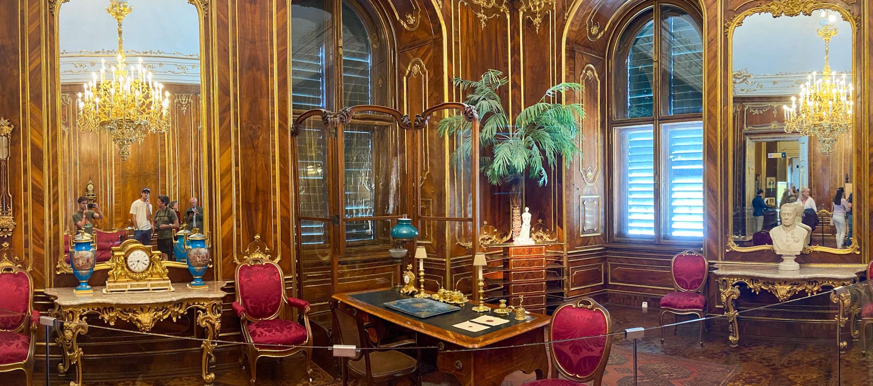 There is a room with a table, chairs, and a mirror.