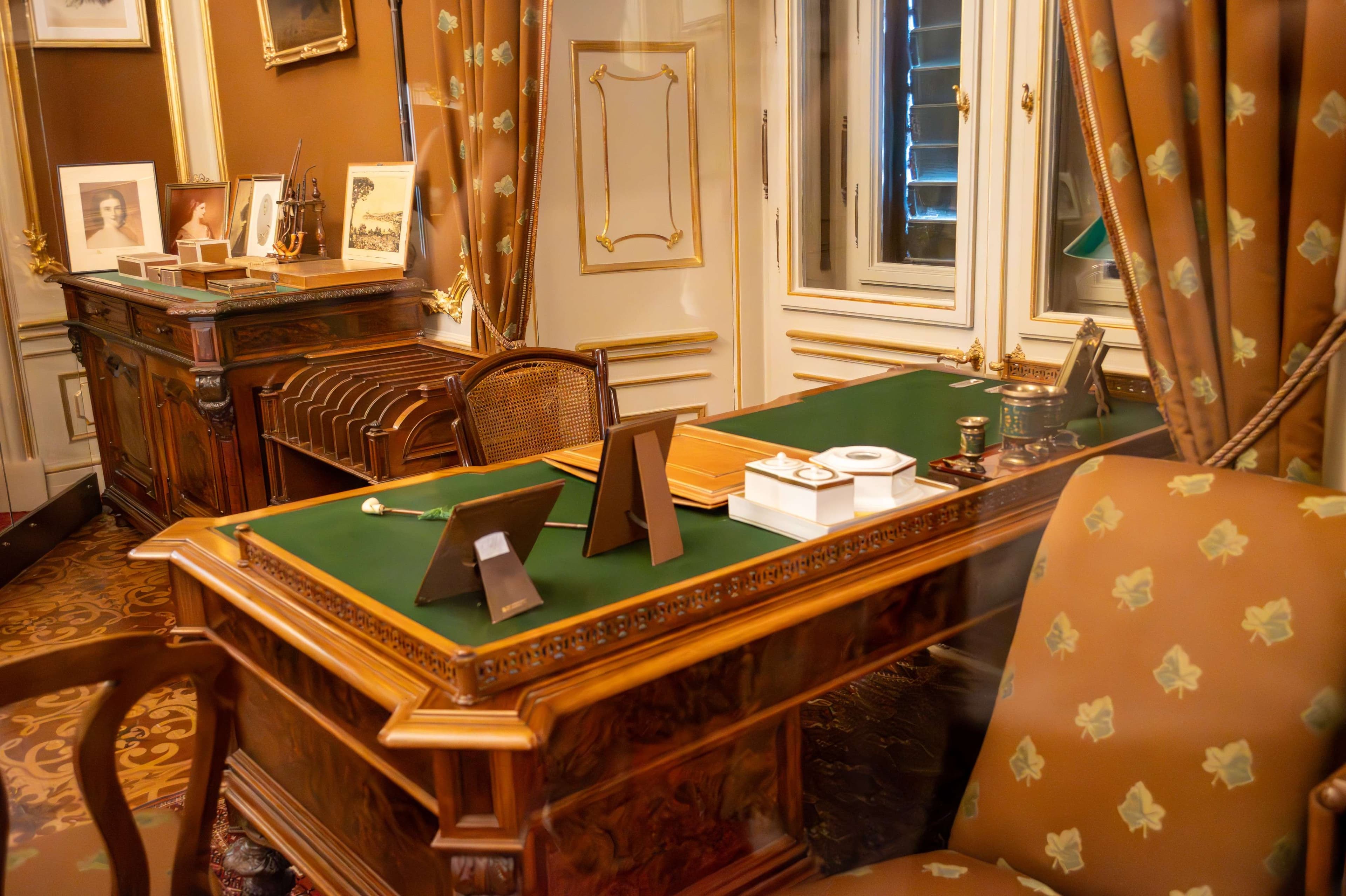 There is a desk with a laptop on it in a room.