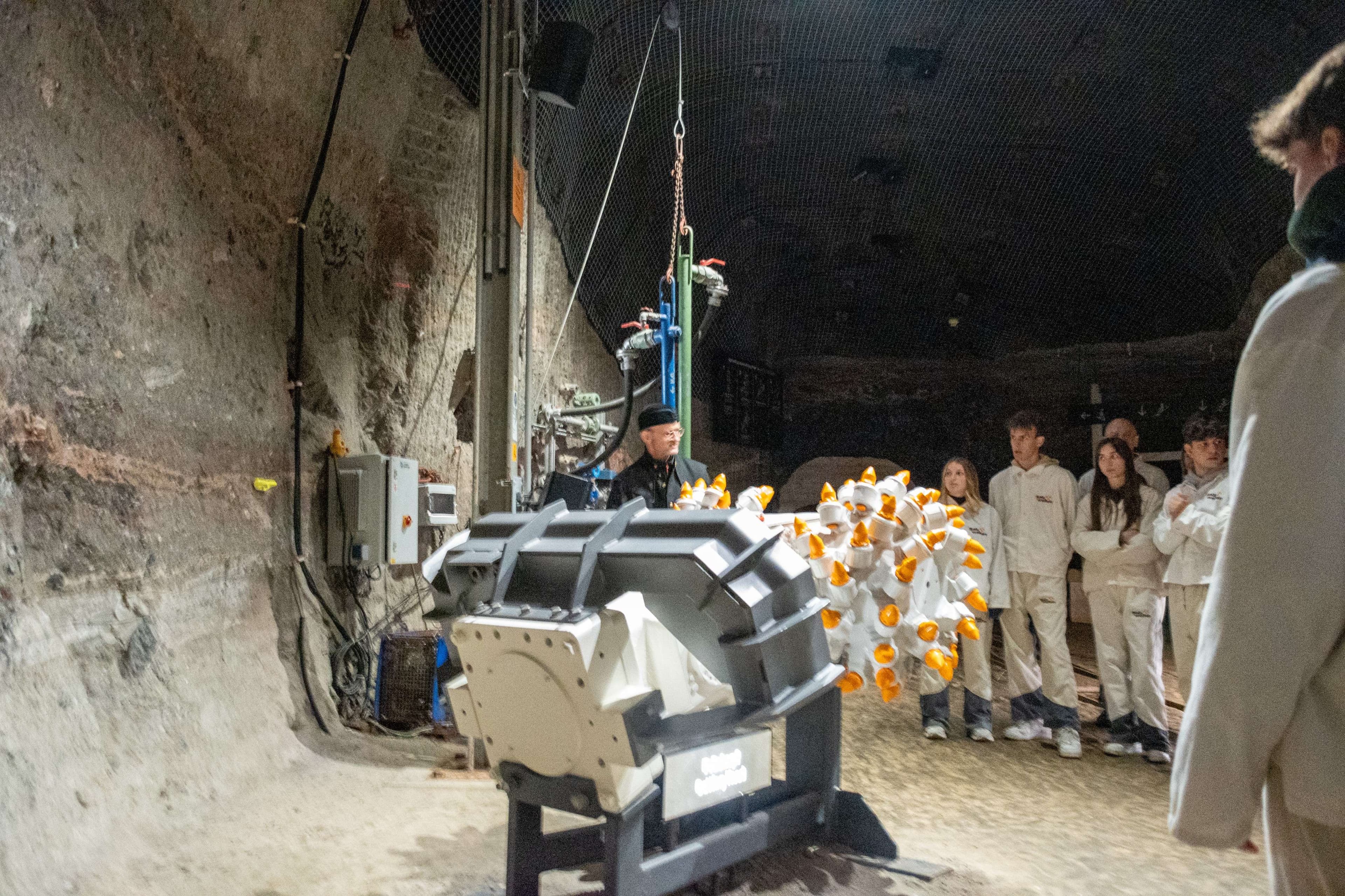 There are many people standing around a machine in a building.