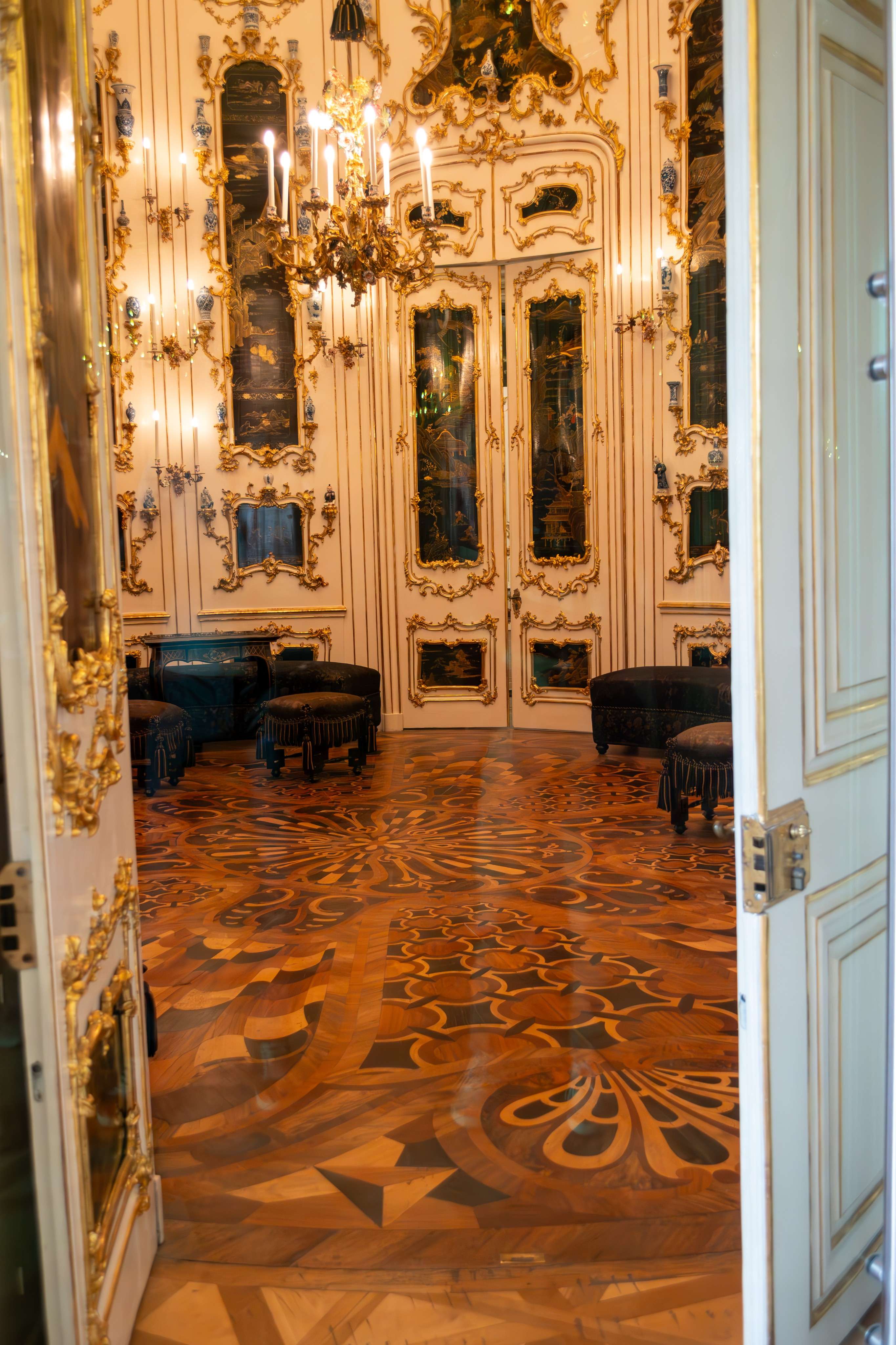 Doorway view of a room with a piano and chandelier.