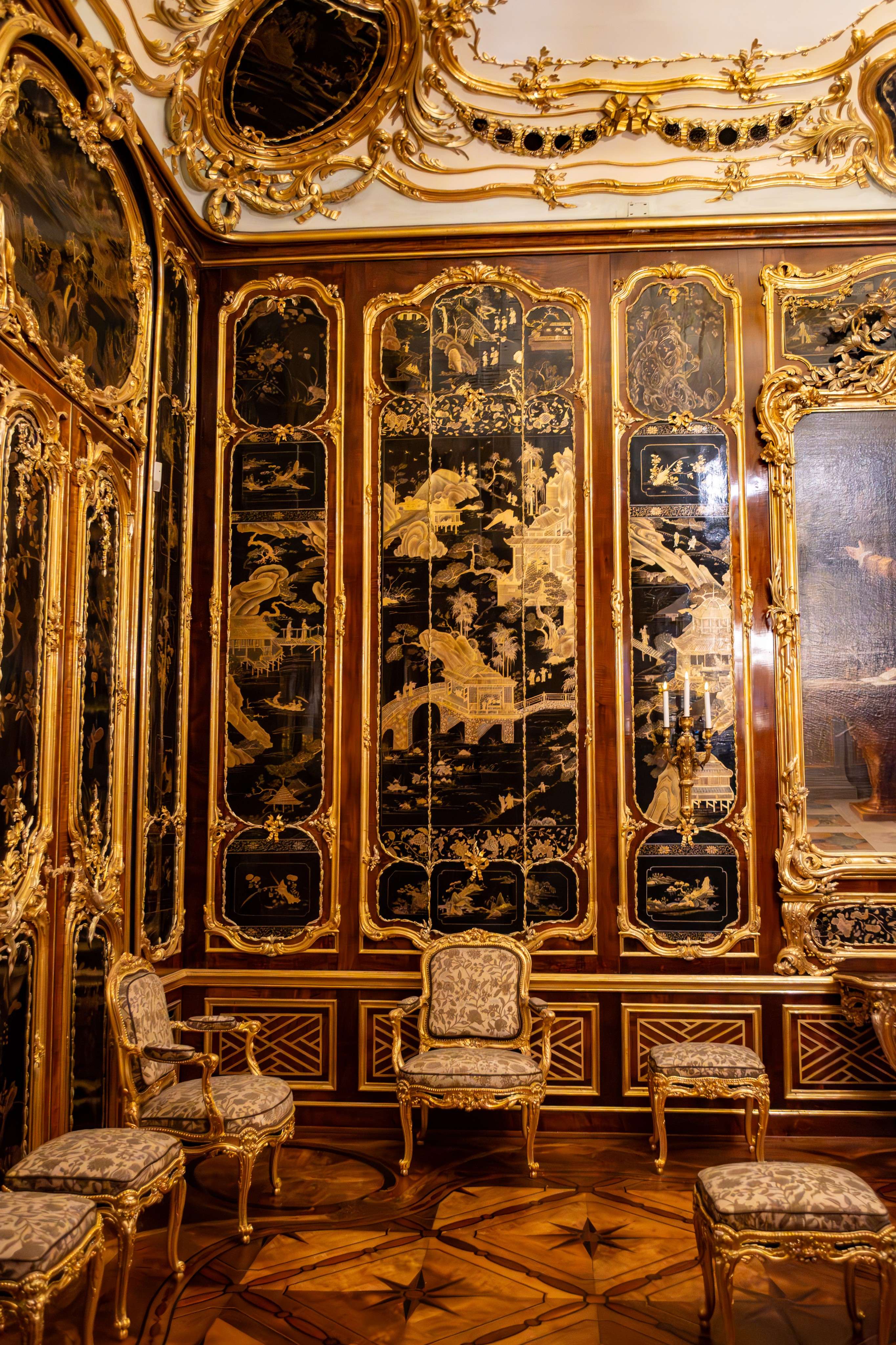 There is a room with a gold and black wall and a gold chair.