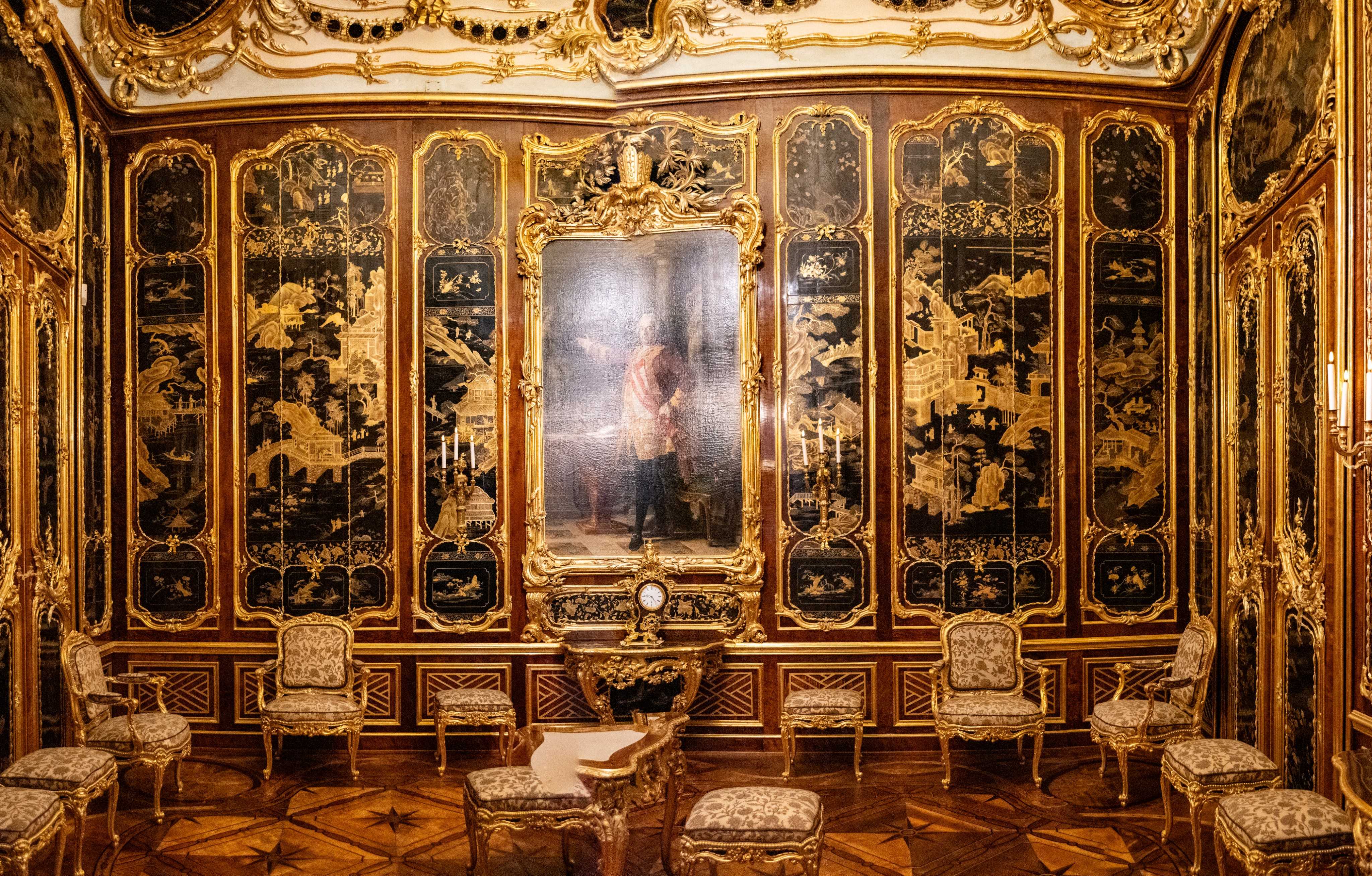 There is a room with a painting and chairs in it.