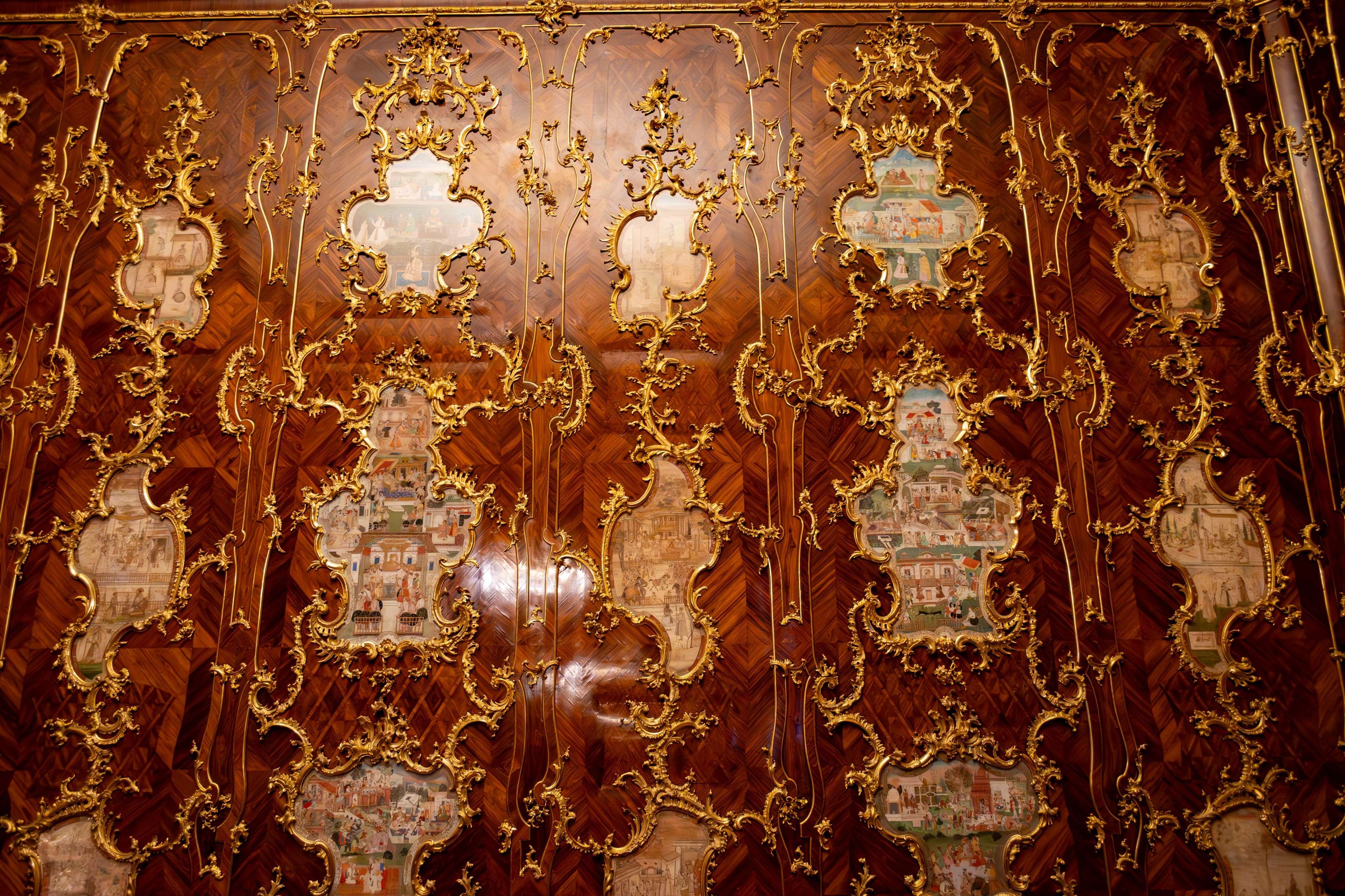 There is a large wooden panel with gold decorations on it.