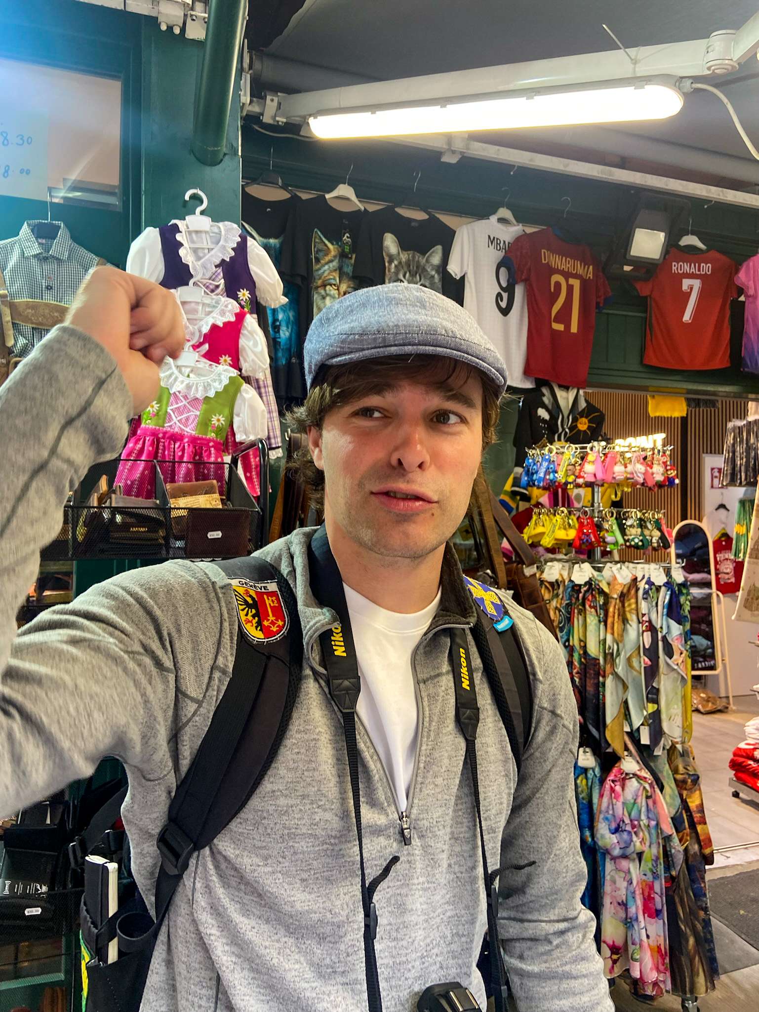 Arafed man in a hat and jacket holding a camera in a store.