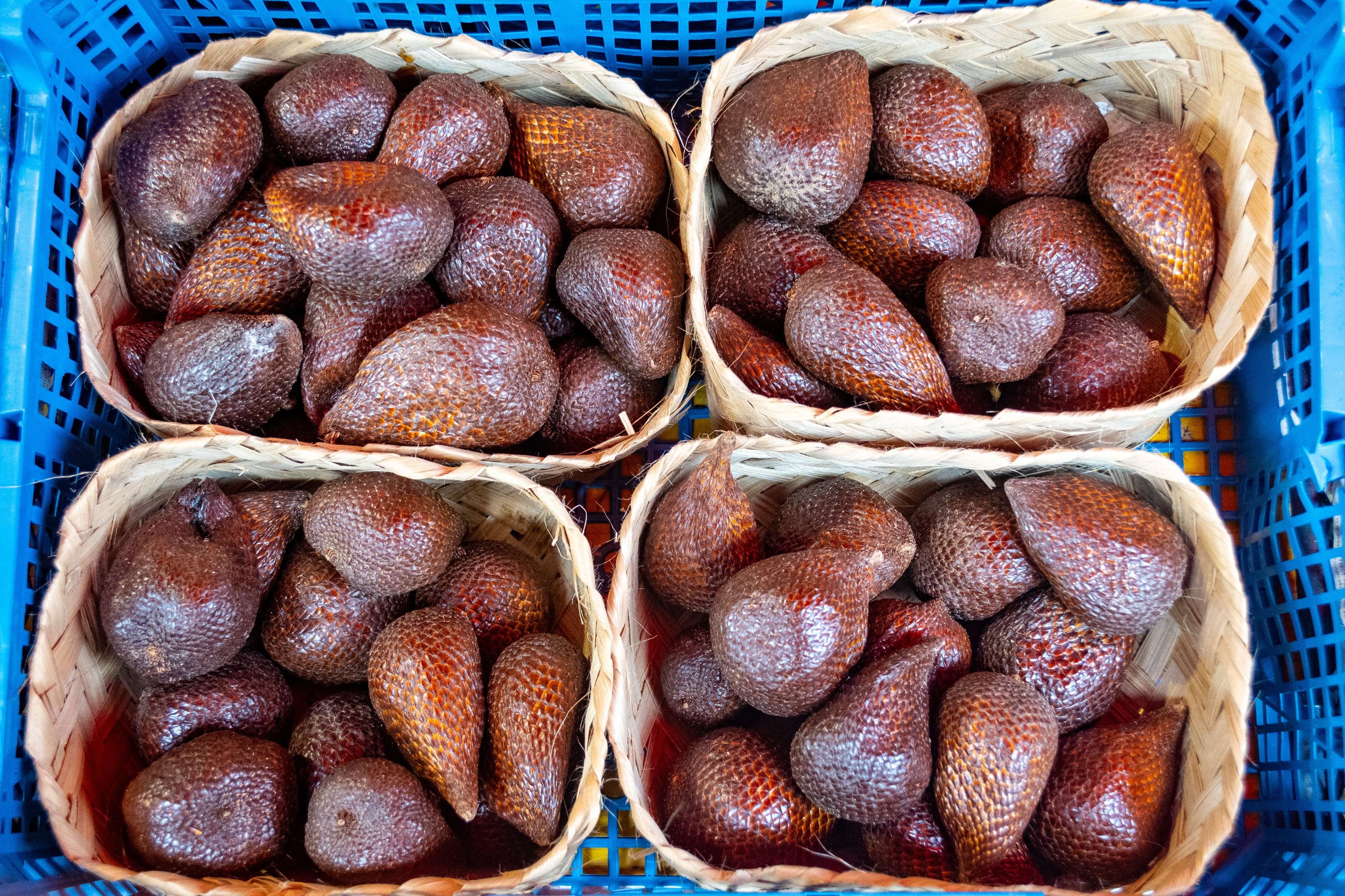 Arafed baskets of strawberries in a blue basket on a table.