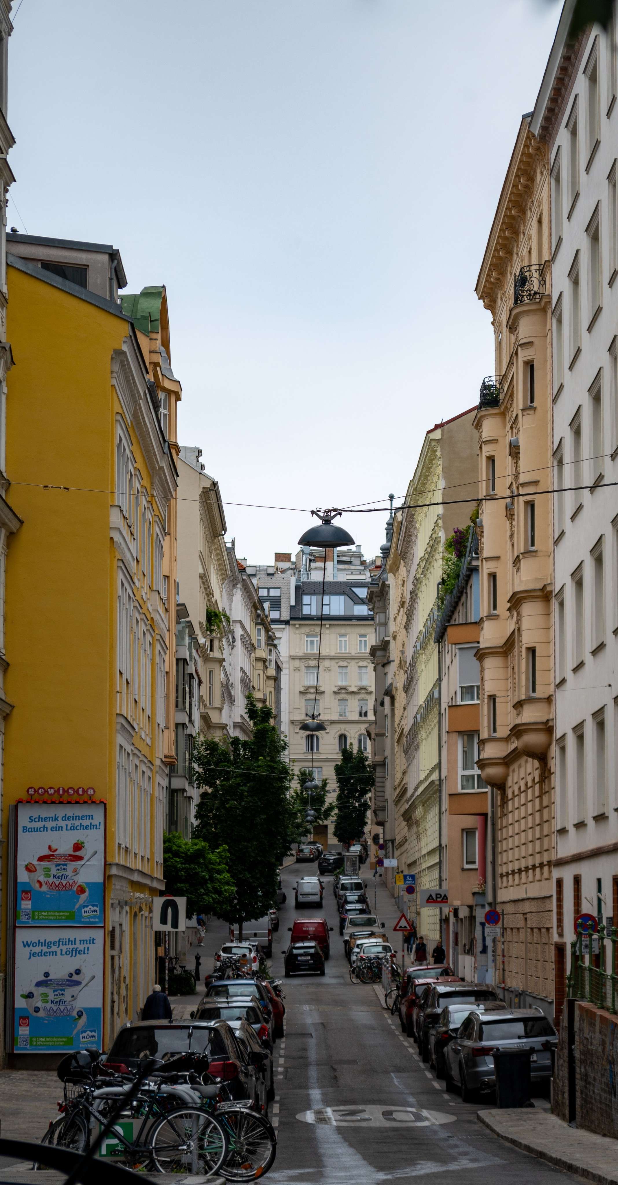 Cars parked on the side of a street in a city.
