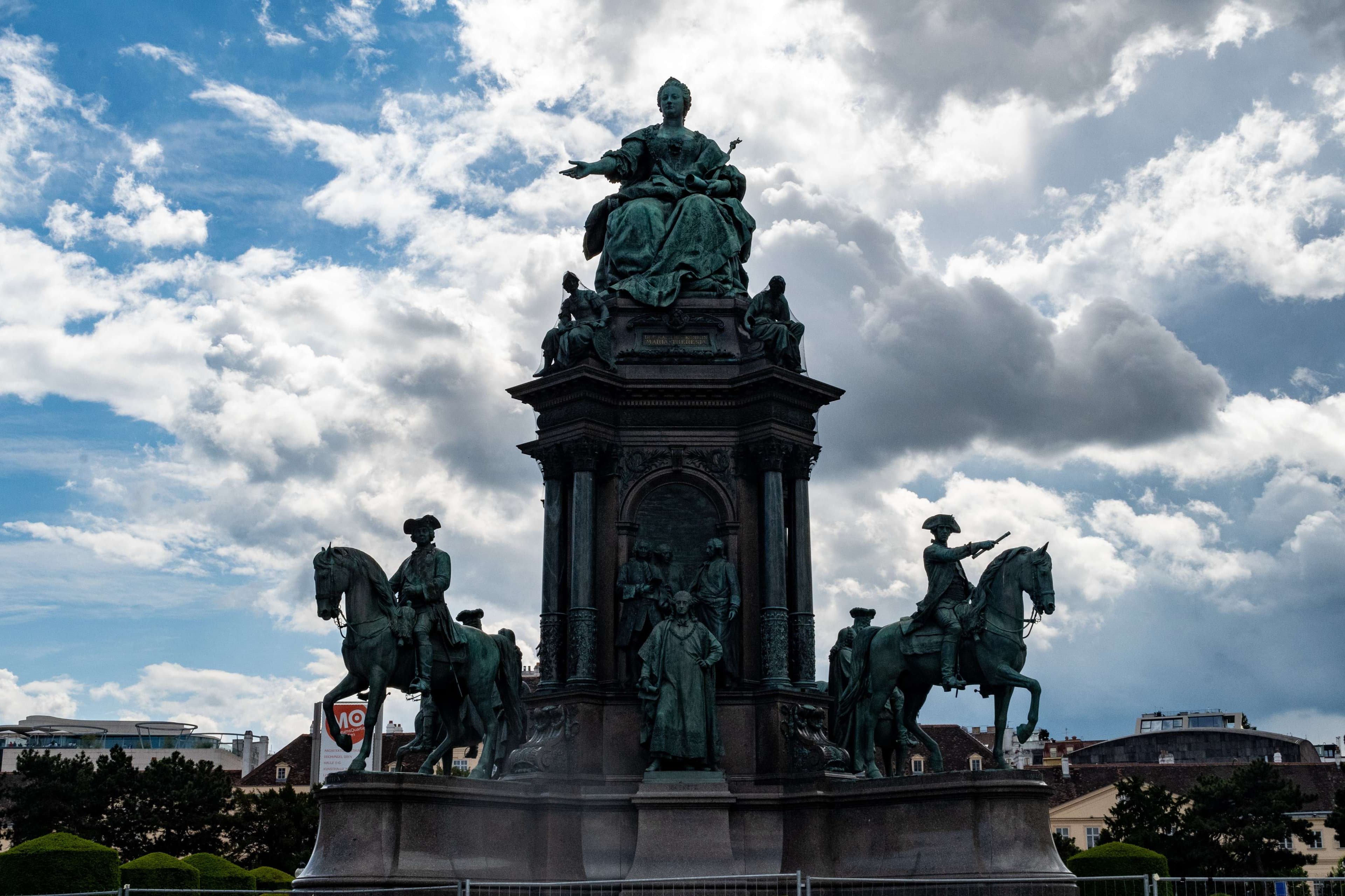 There is a statue of a man riding a horse with a group of people on it.