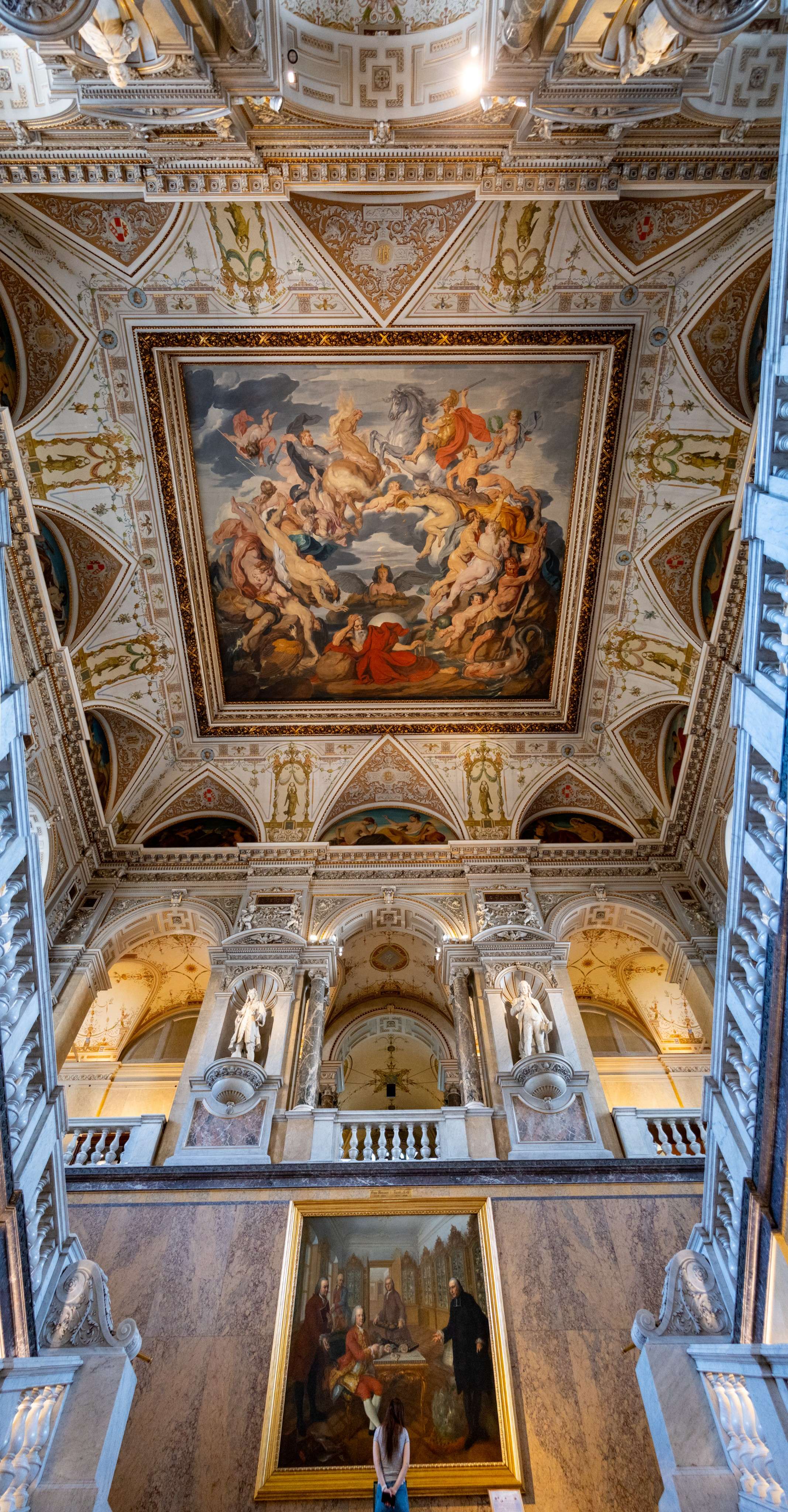 Arafed ceiling with a painting and a woman standing in front of it.