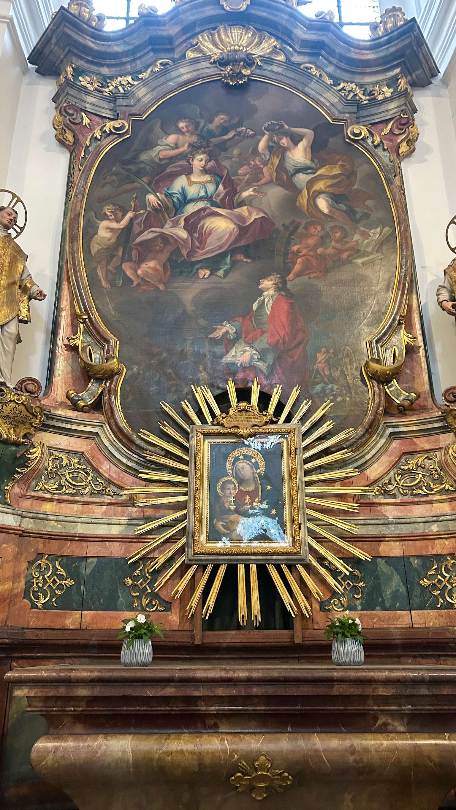 There is a painting on the wall of a church with a sunburst.