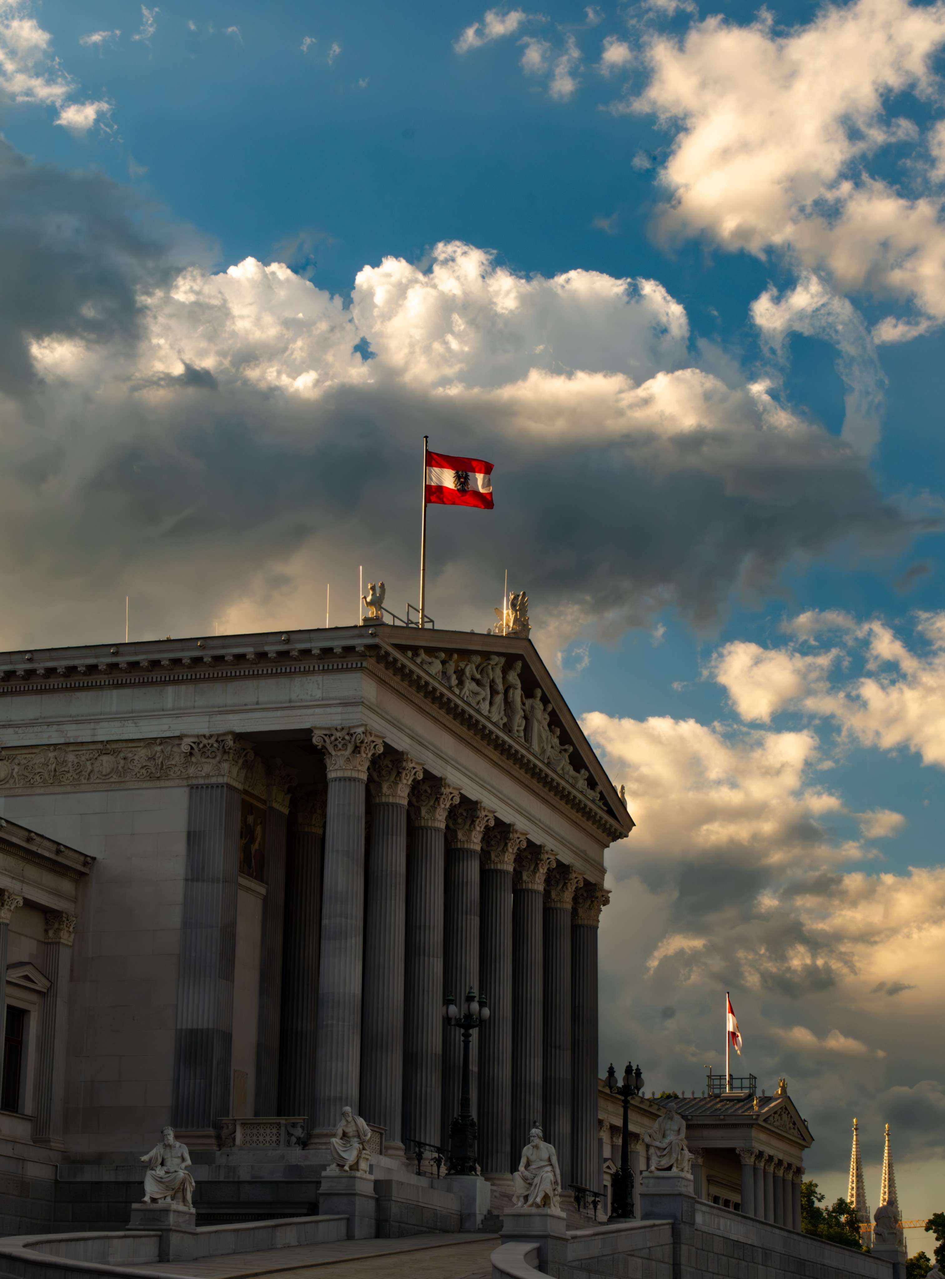 Cloudy sky with clouds and a flag on top of a building.