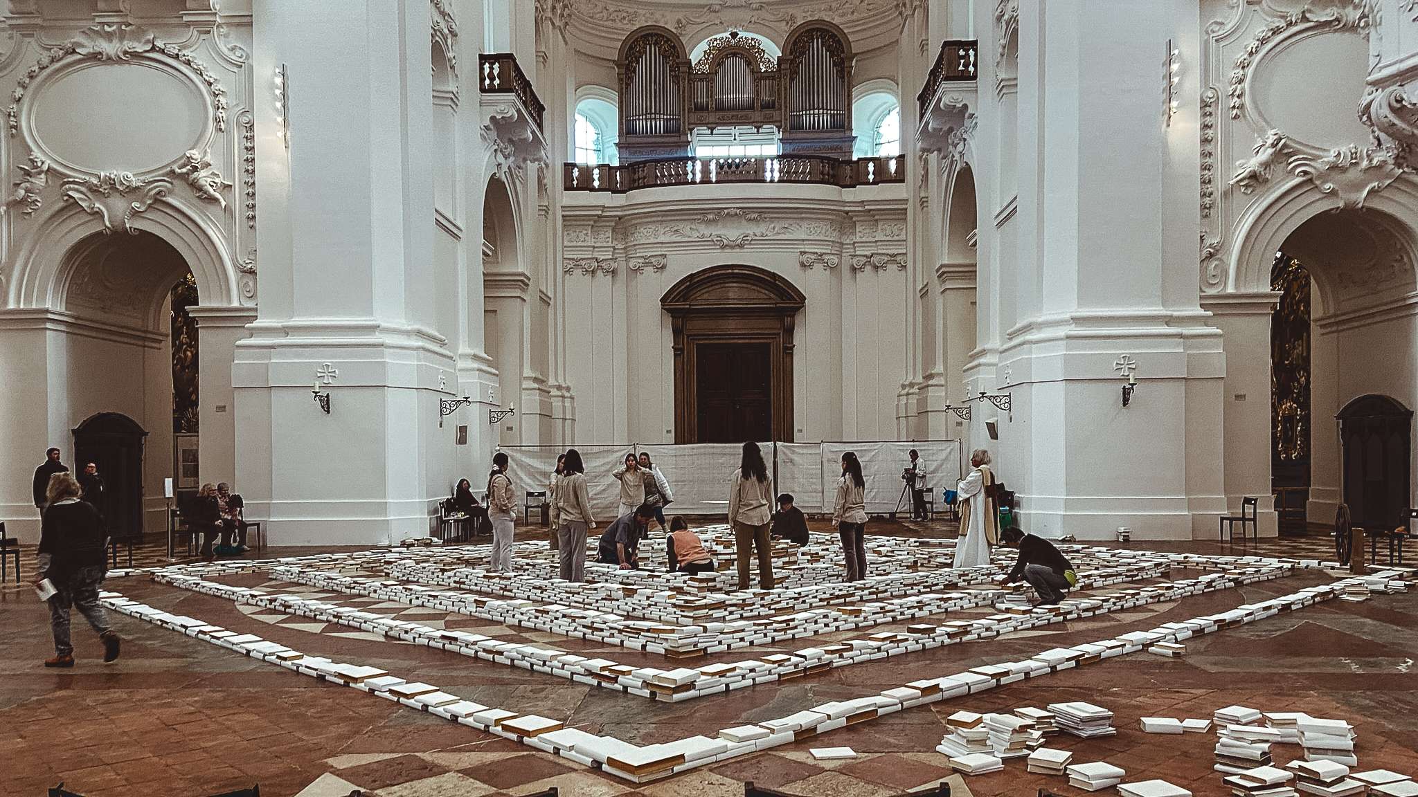 People are standing in a large room with a lot of boxes on the floor.