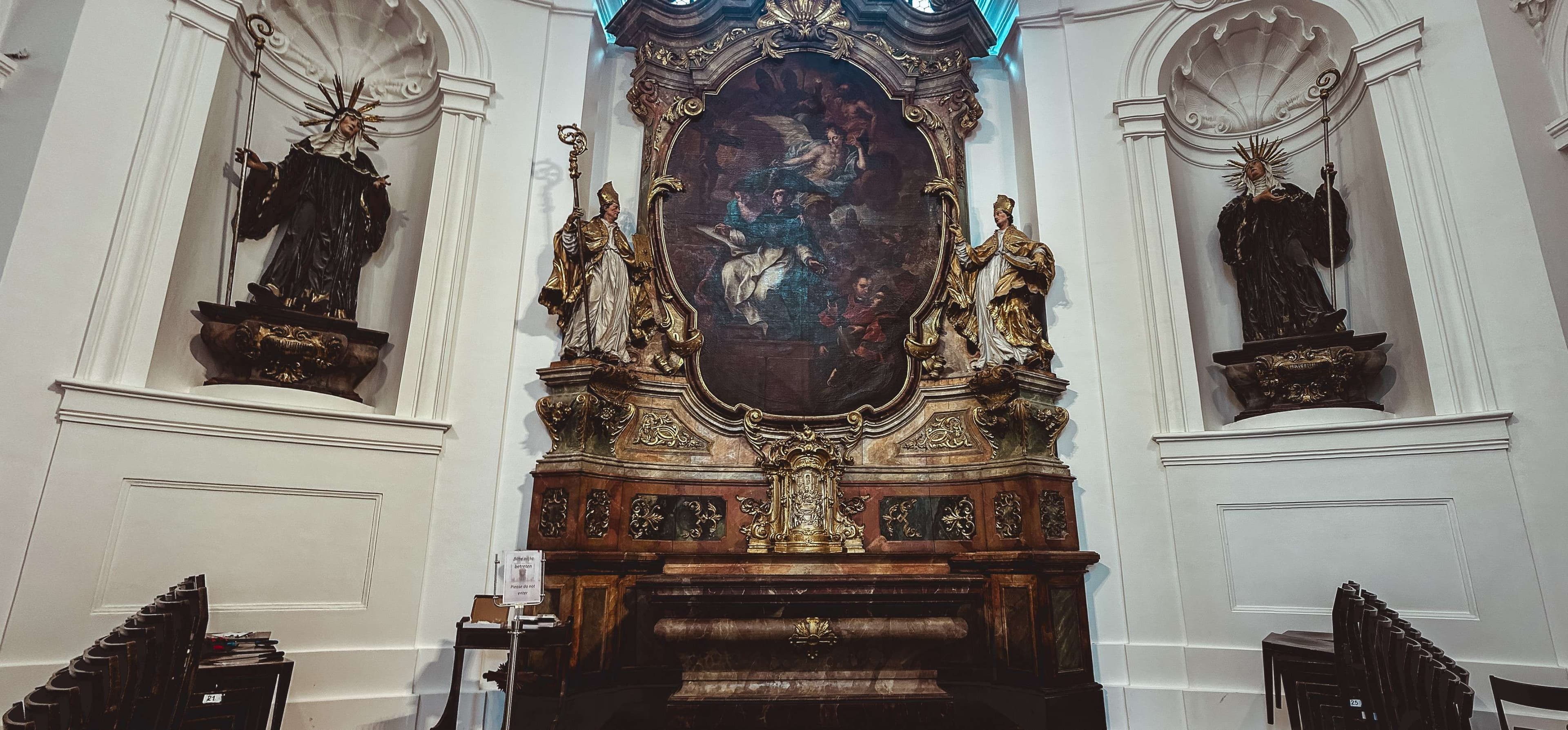 There is a large ornate painting on the wall of a church.
