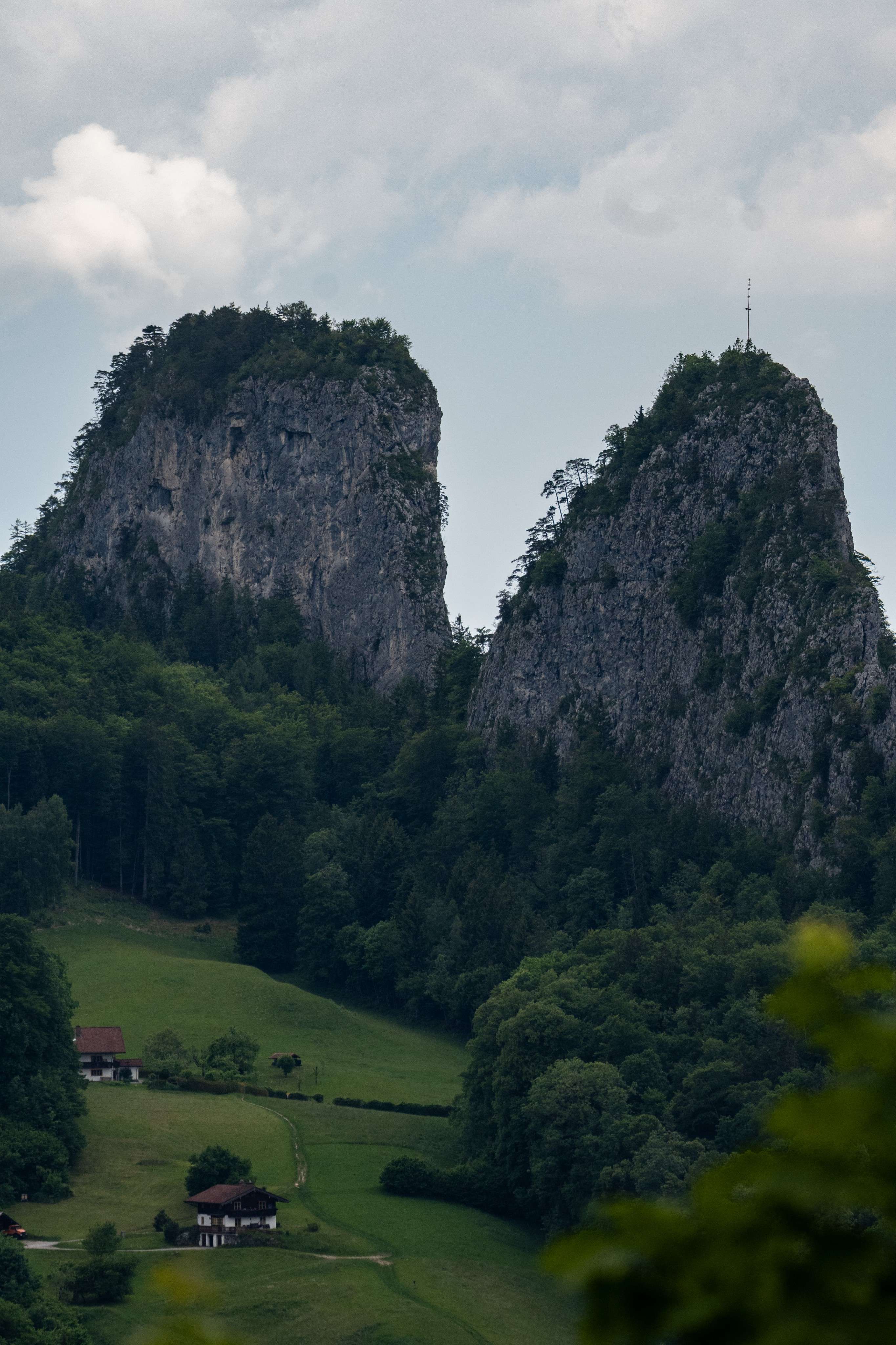 There is a small house in the middle of a green valley.