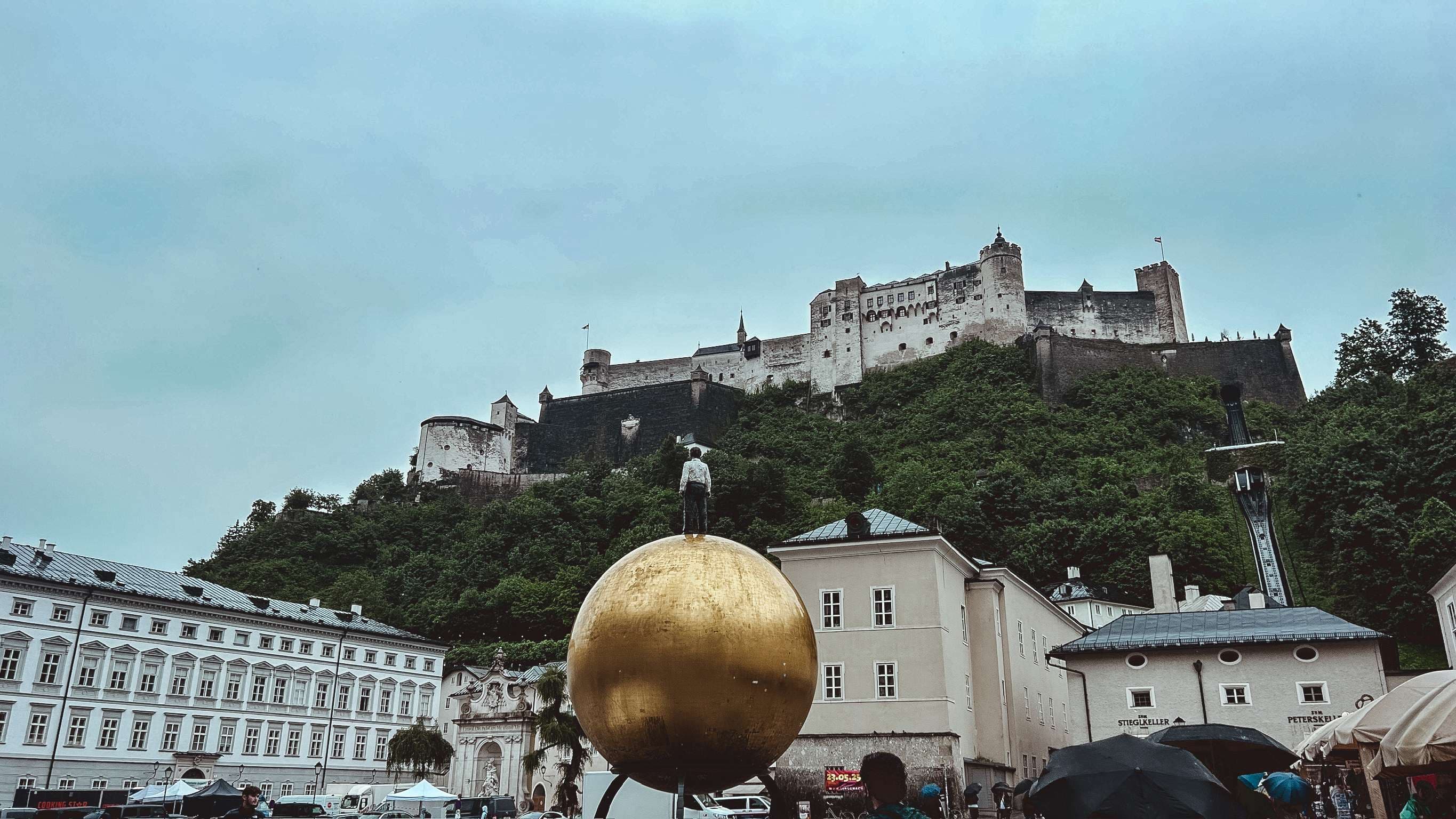There is a large golden egg in front of a castle on a hill.