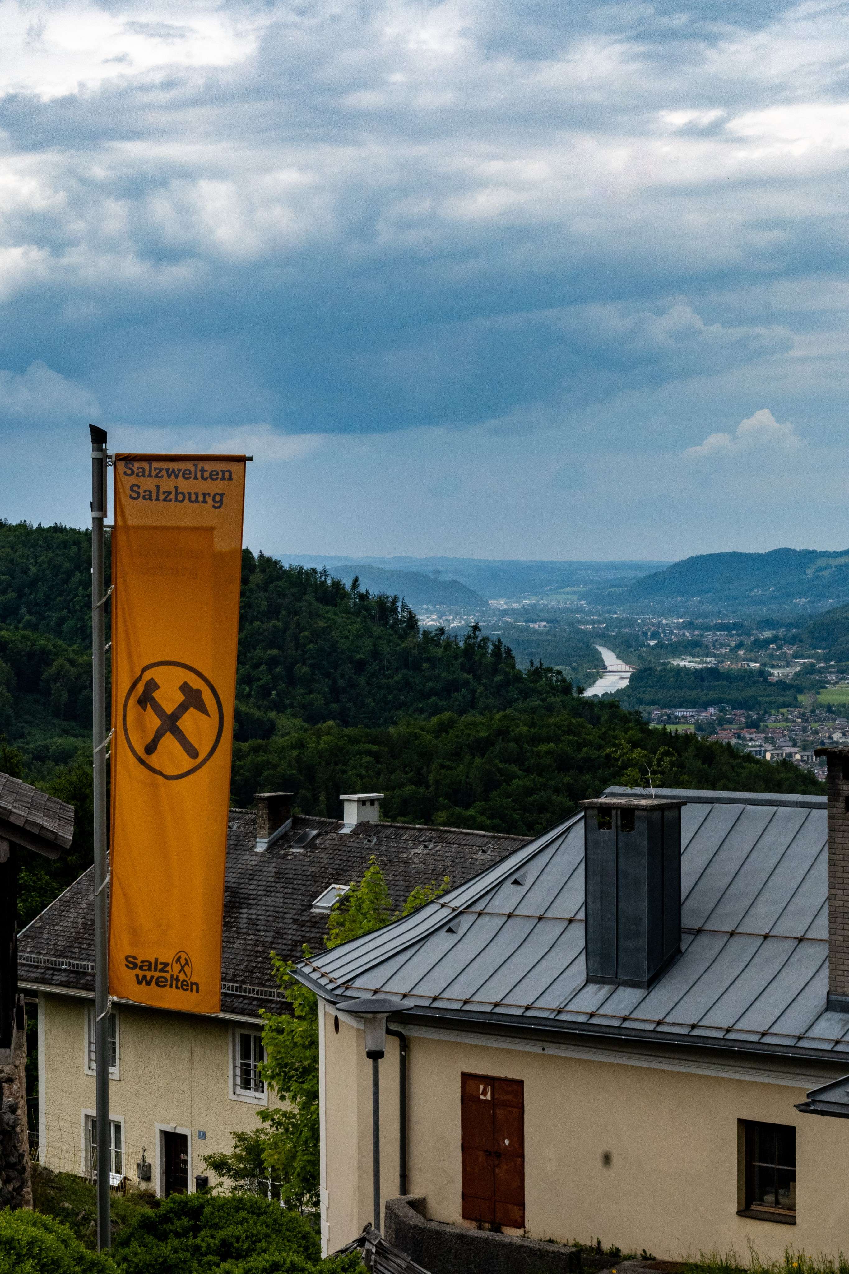 There is a yellow banner hanging from a building on a hill.