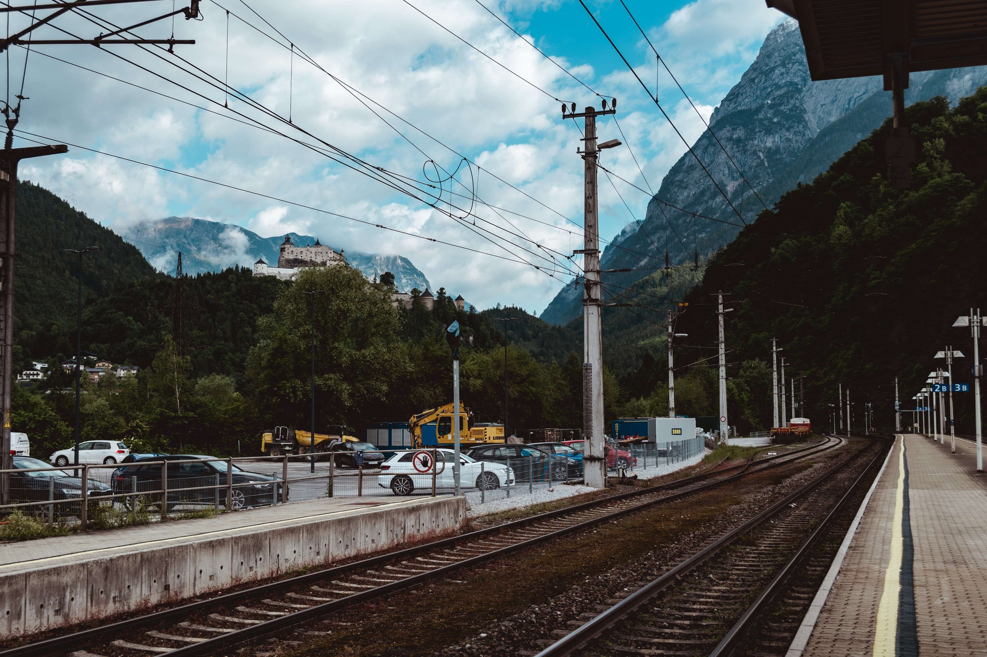 There is a train station with cars parked on the tracks.