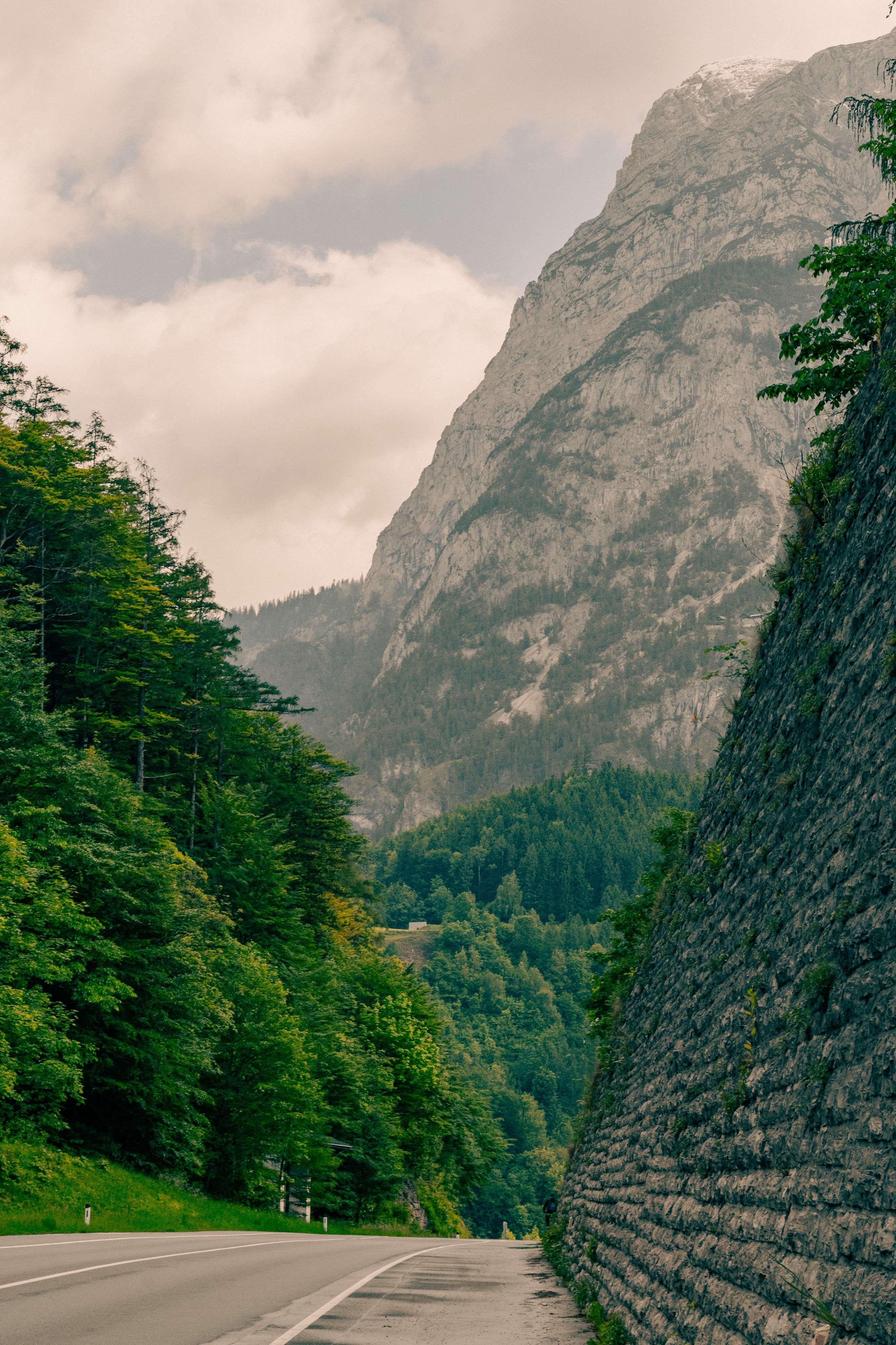 There is a road going through a mountain with a mountain in the background.