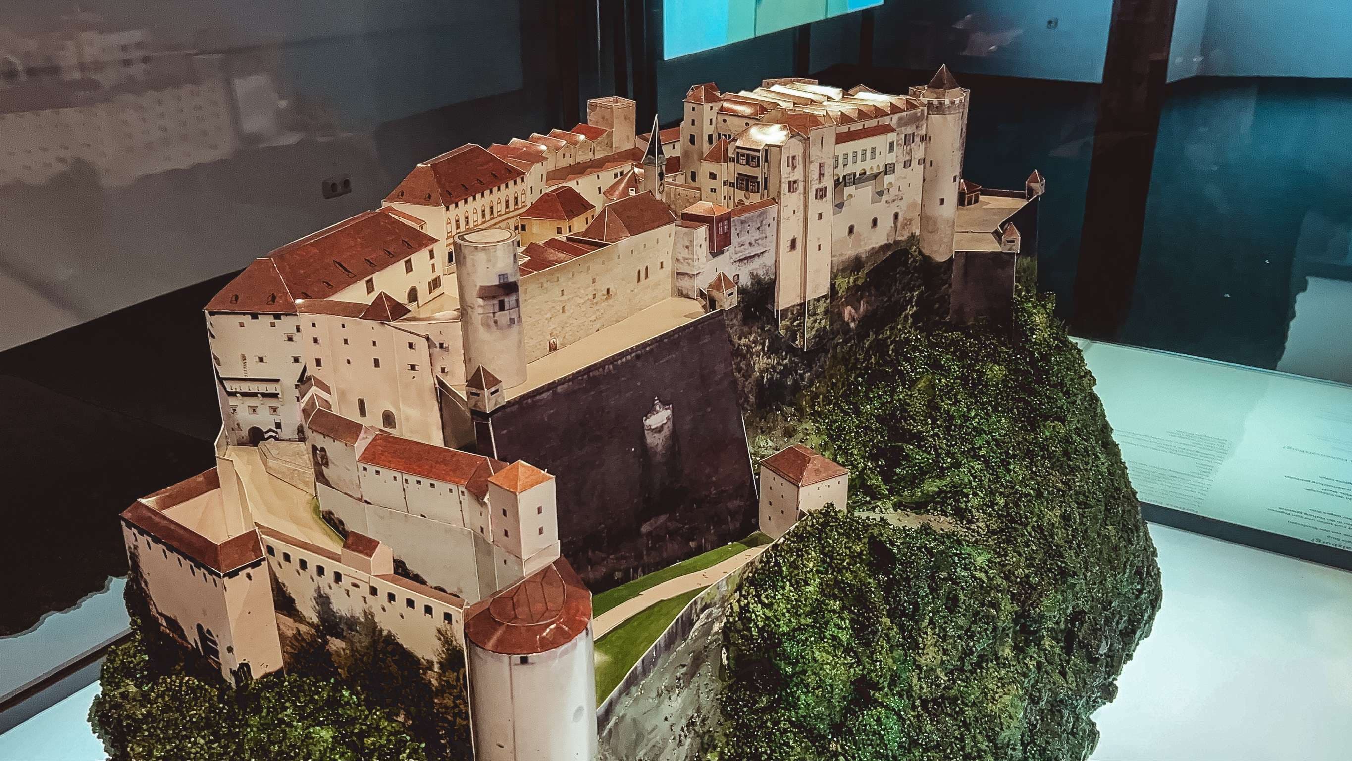 There is a model of a castle on a hill with trees.