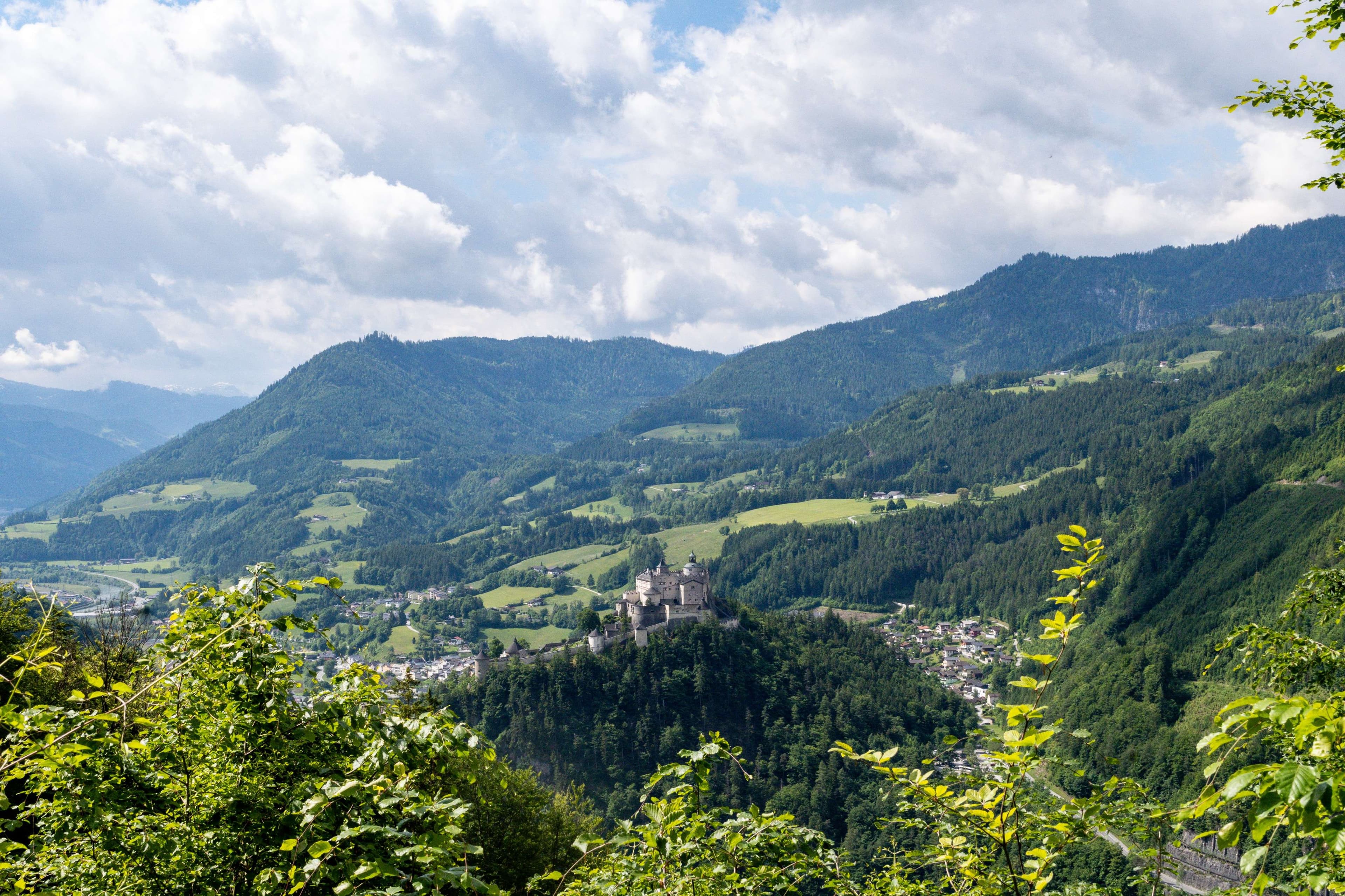 Mountains with a castle in the distance and a few trees.
