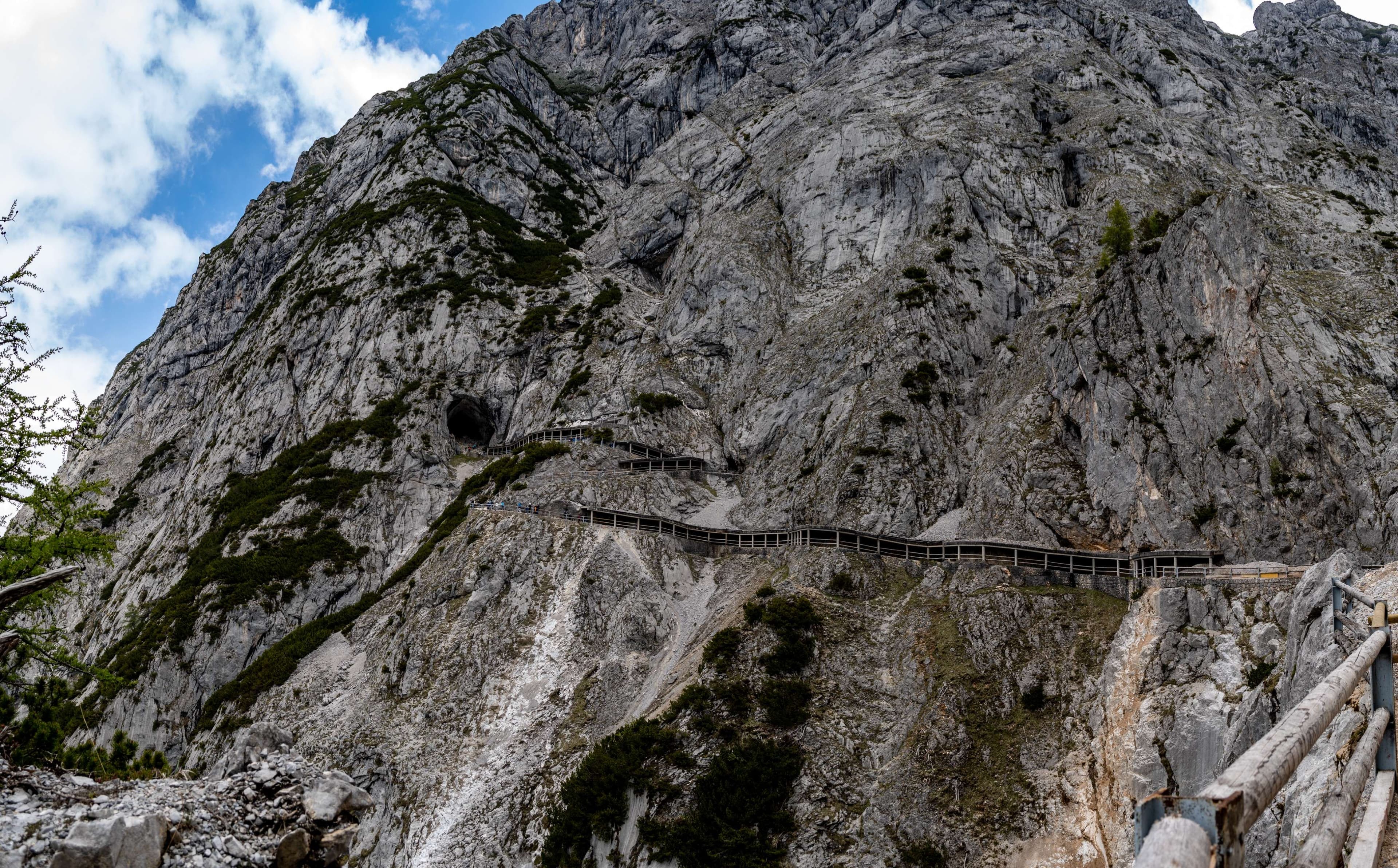 There is a wooden walkway going up a mountain side.