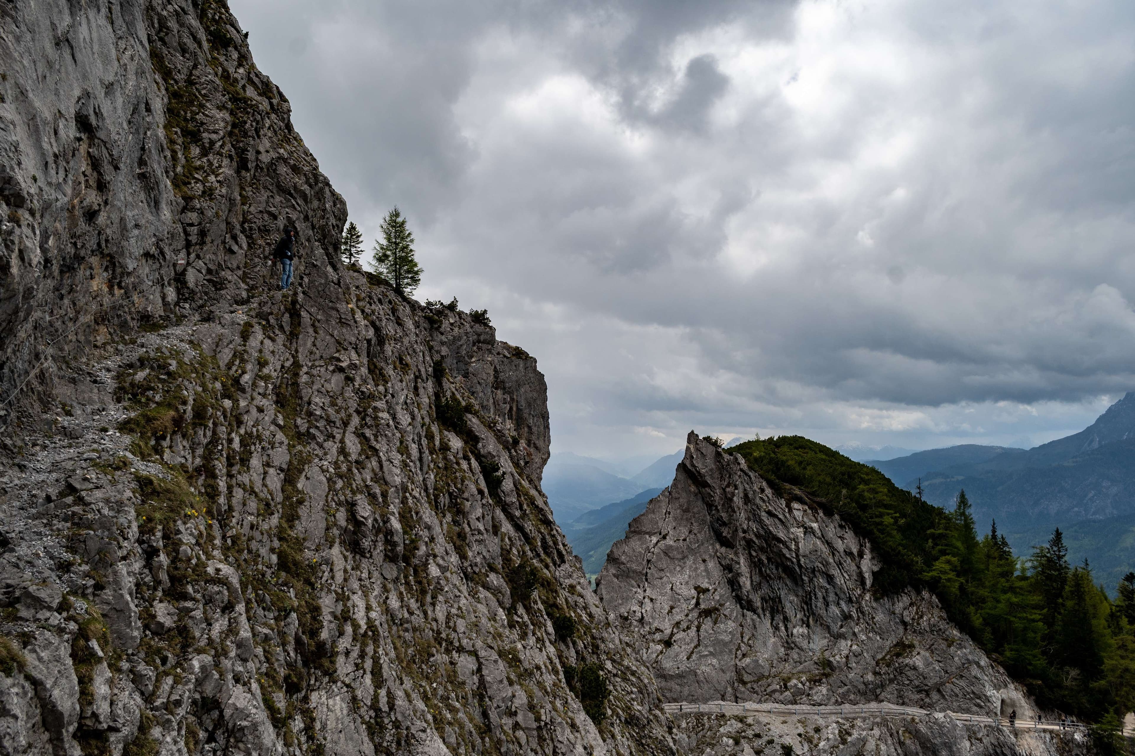 There is a man riding a horse on a mountain side.