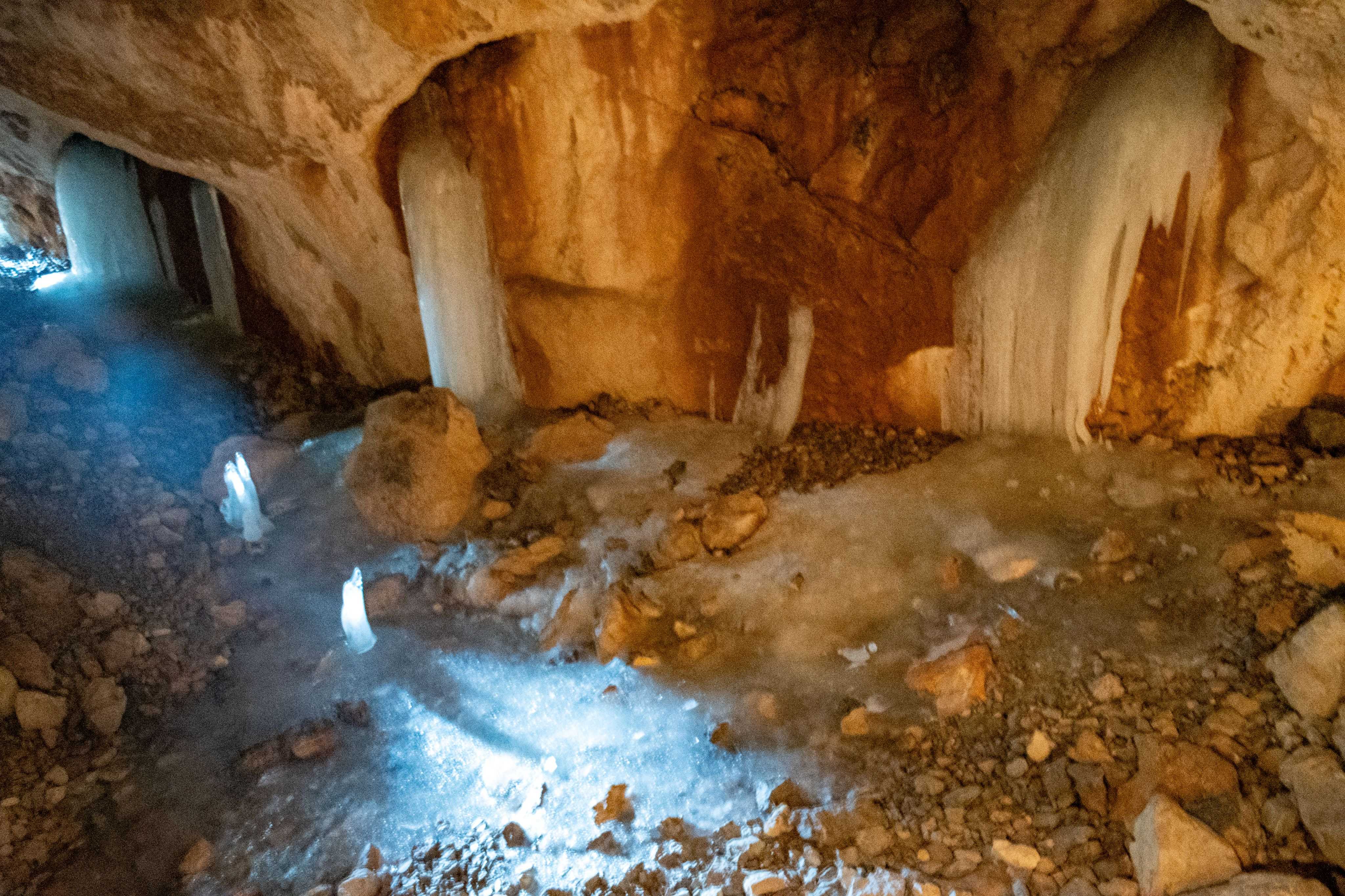 There is a cave with ice and water inside of it.