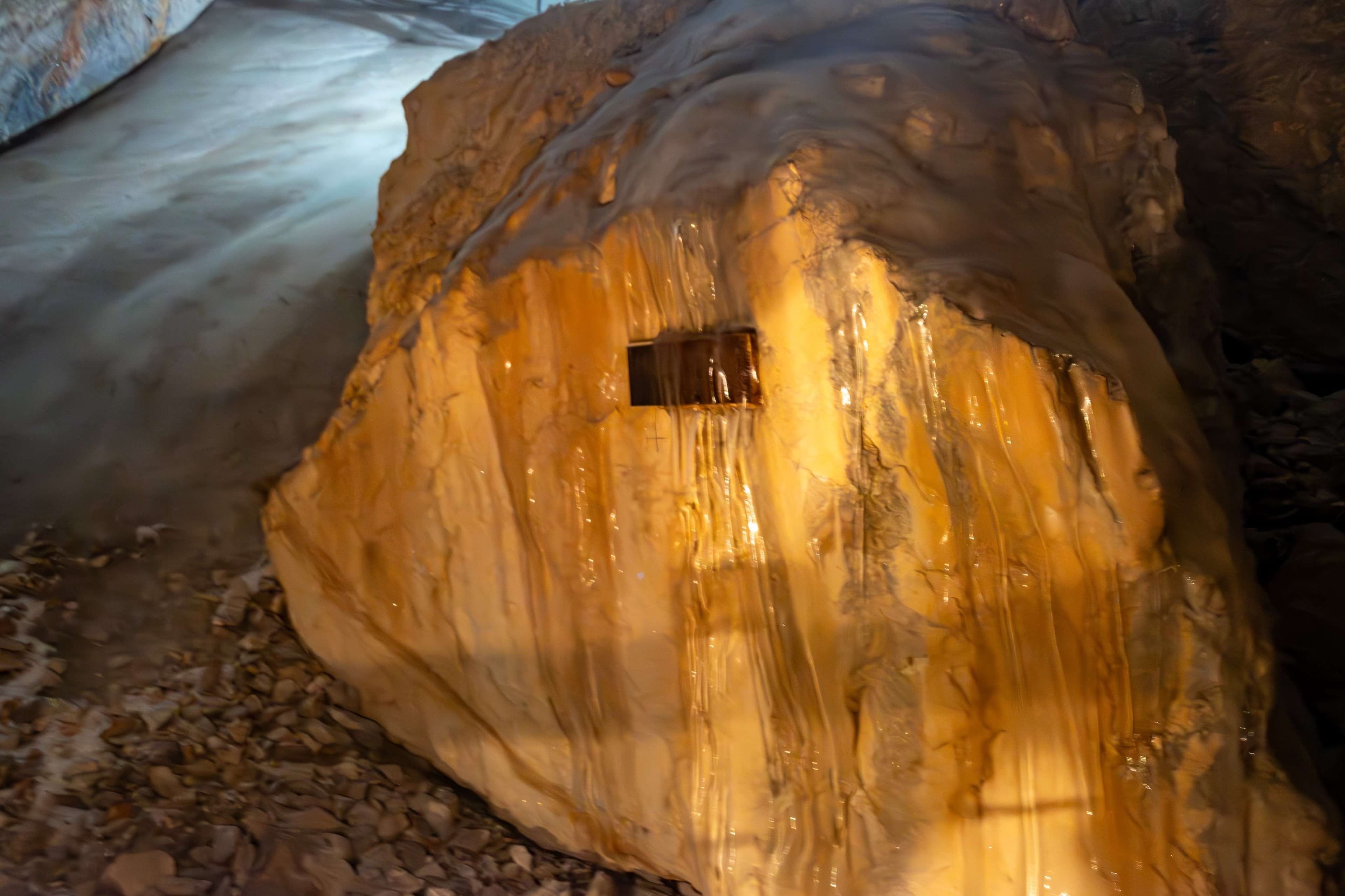 There is a rock with a hole in it sitting on a rock.
