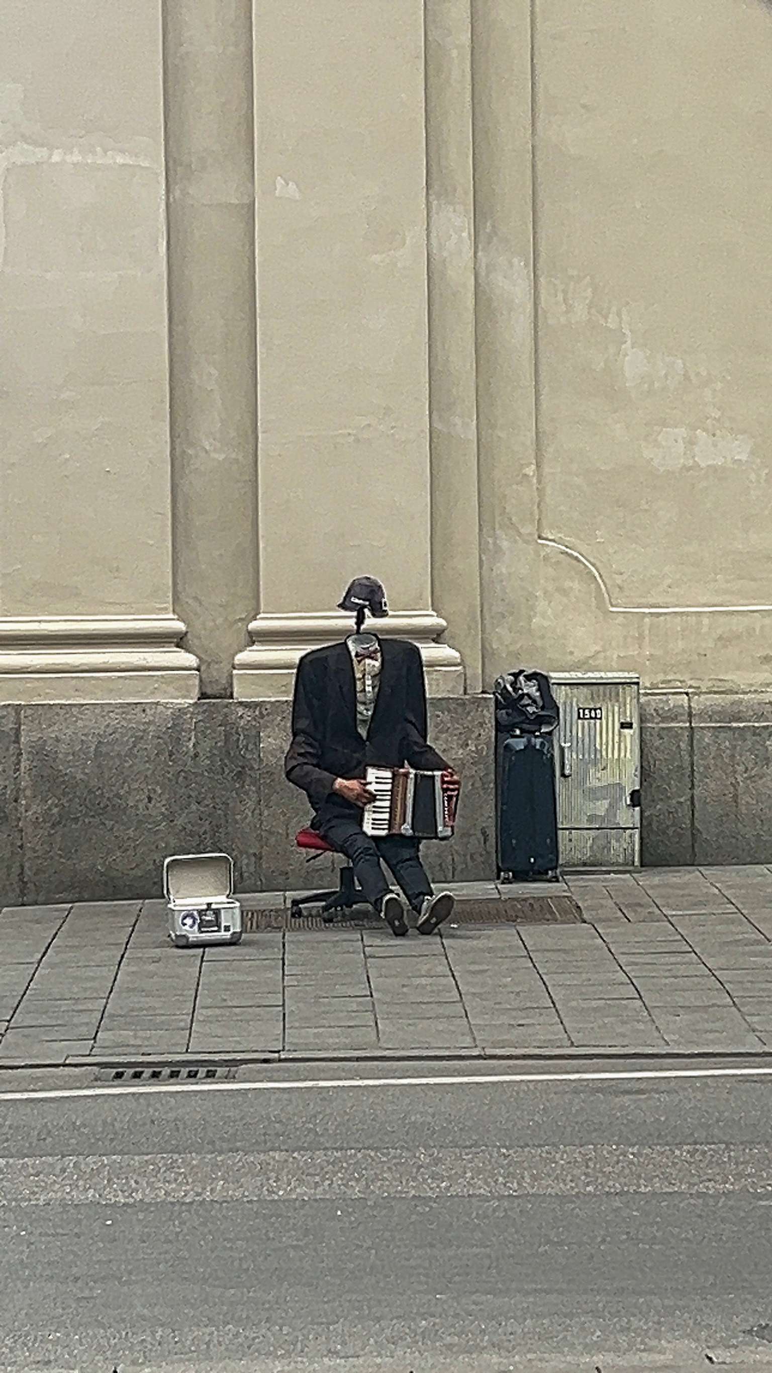 There is a man sitting on a bench with a suitcase.