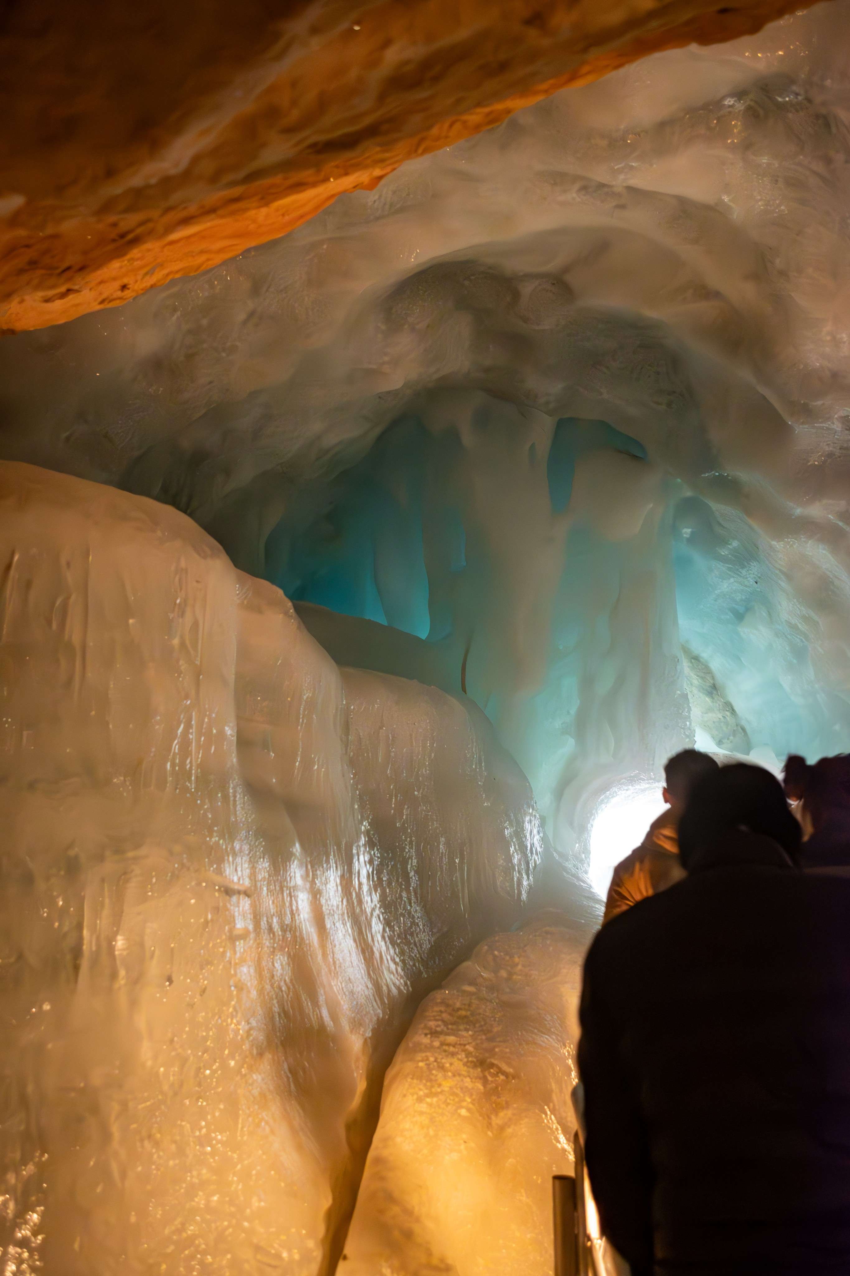 People are standing in a cave with ice and water.