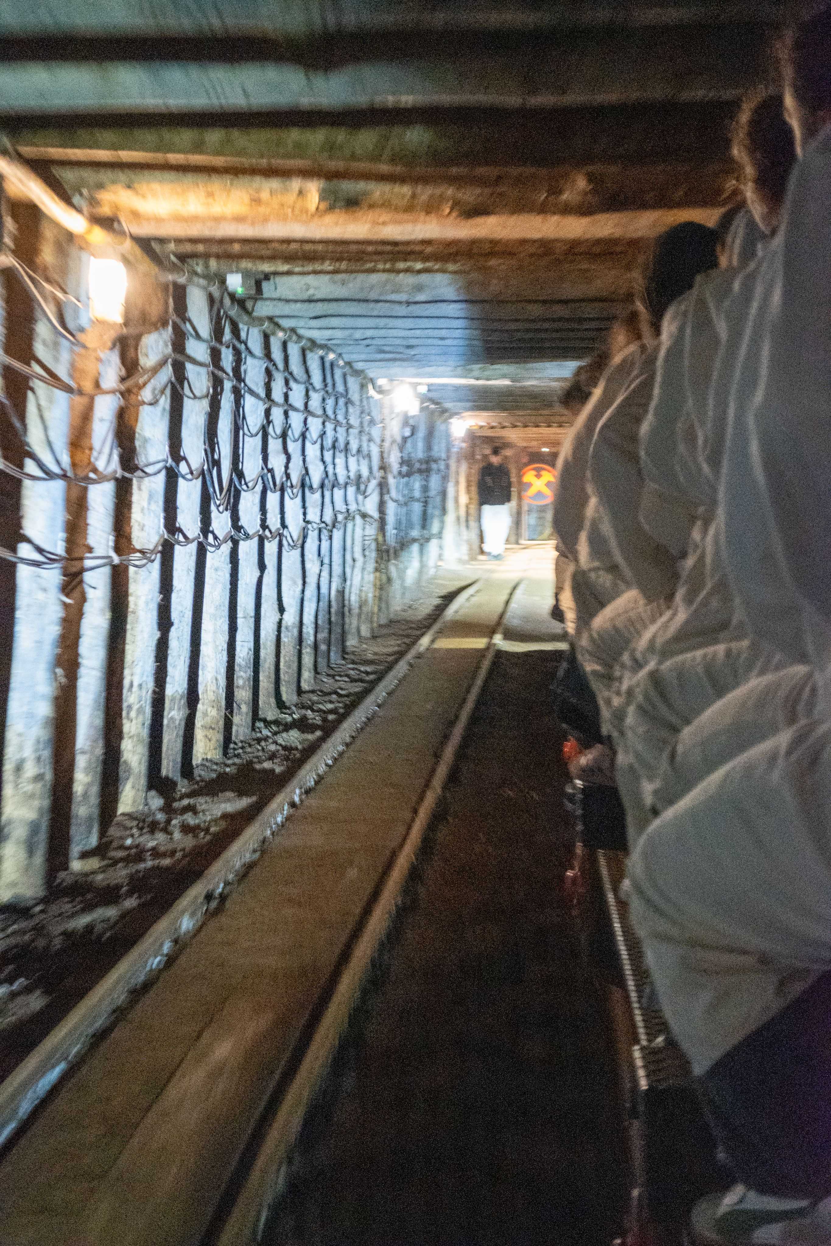 People are riding on a train in a tunnel with a light on.