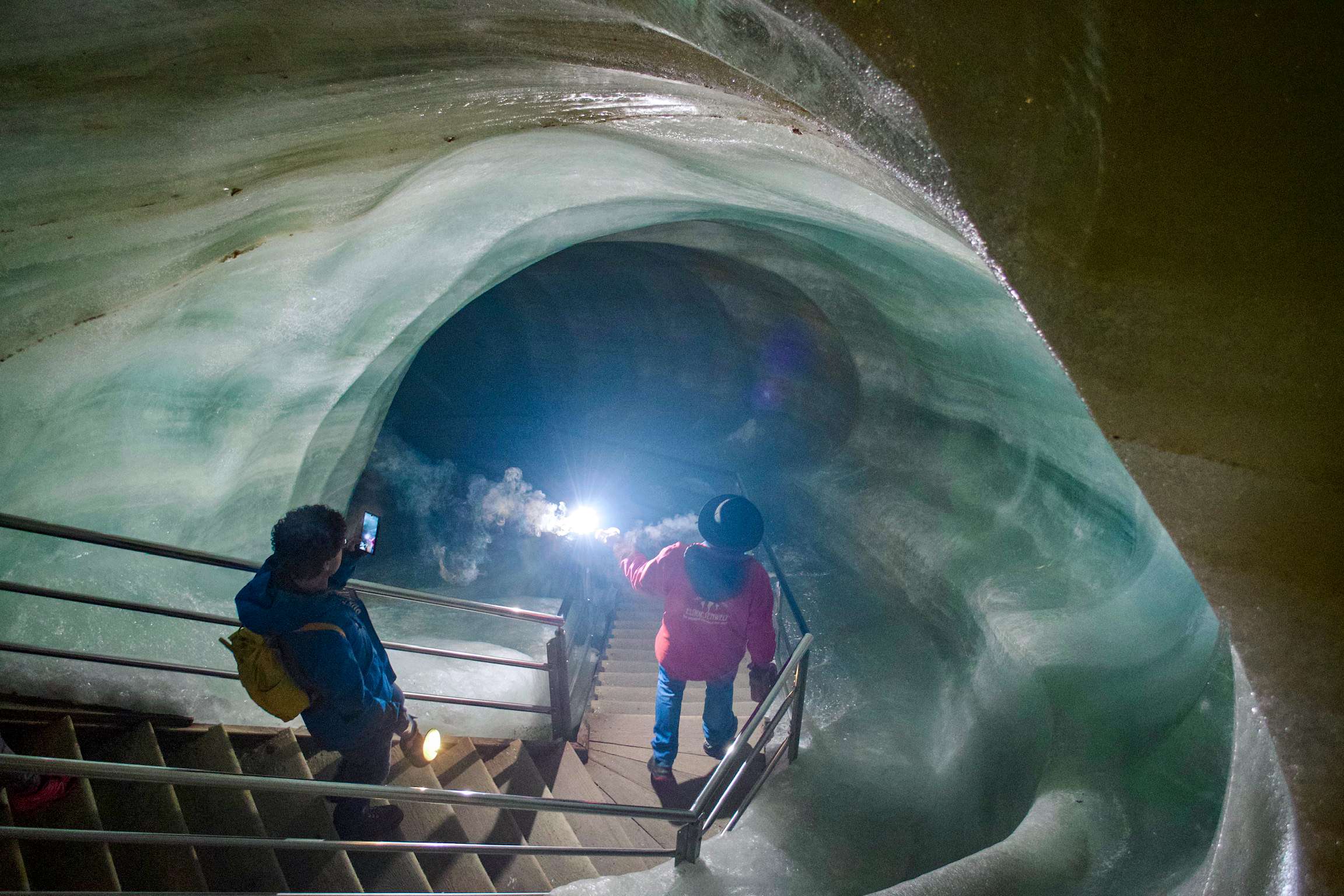 People are walking up a set of stairs in a cave.