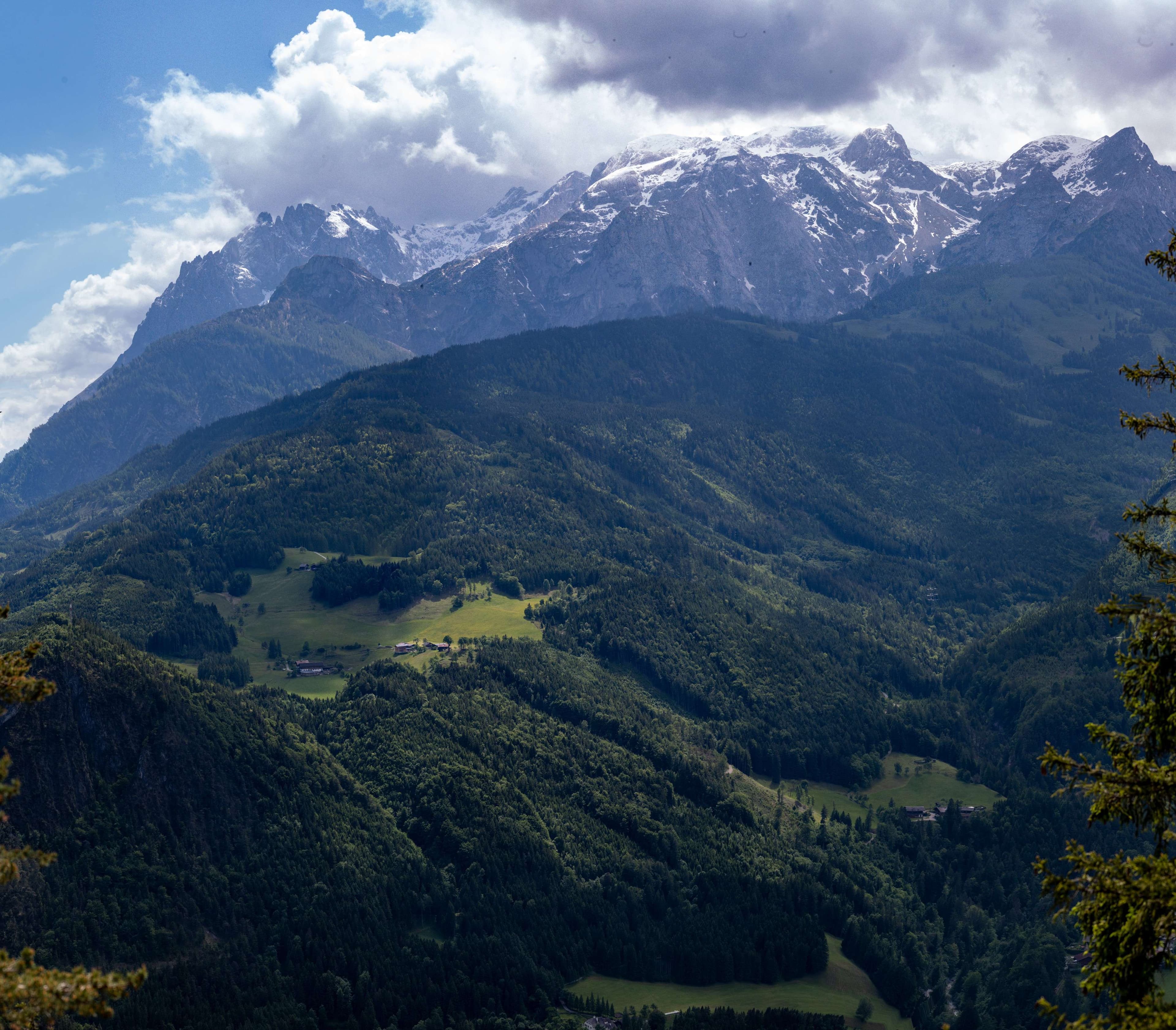 Mountains with a few trees and a few clouds in the sky.