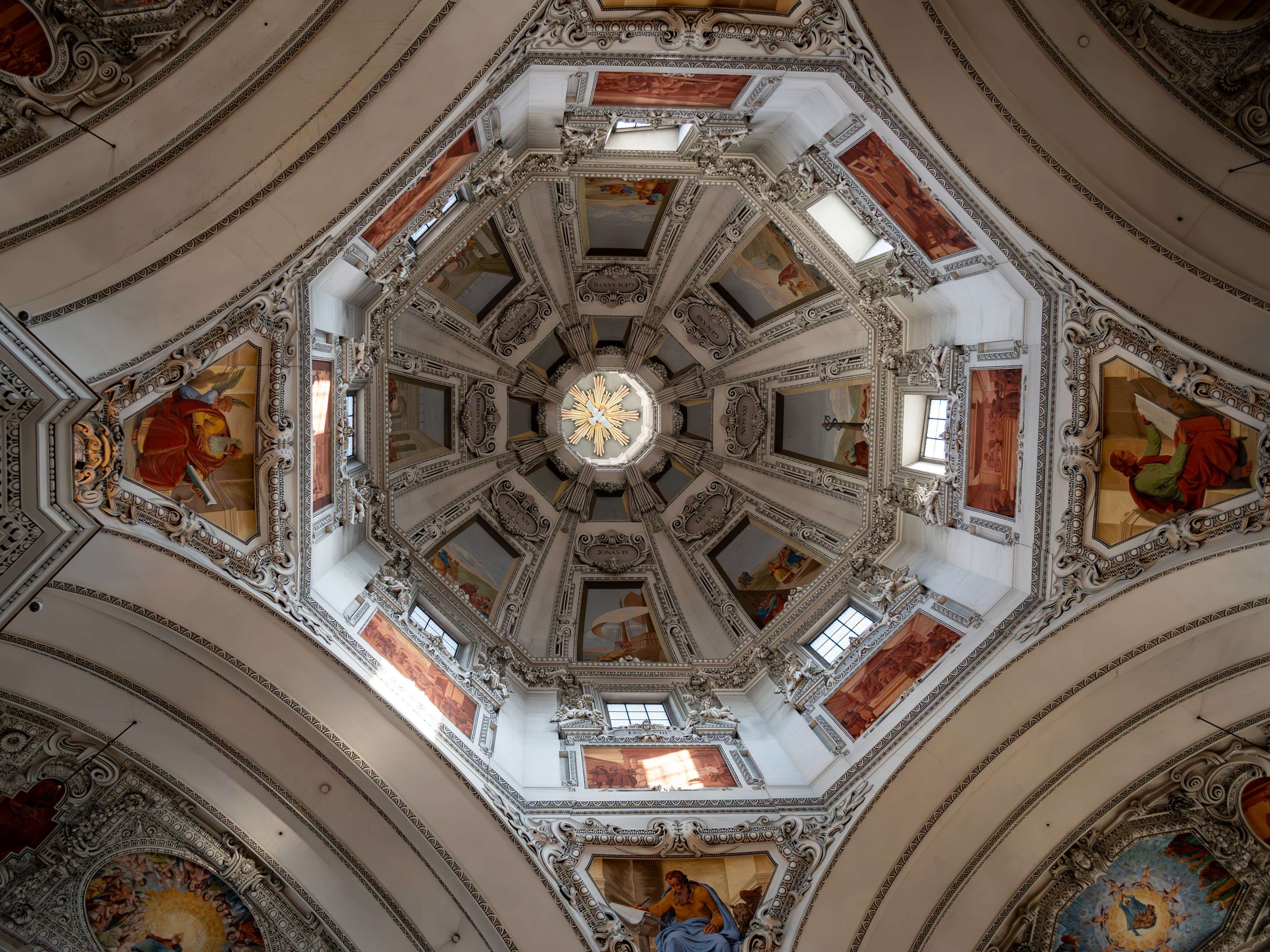 Arafed ceiling with a clock and paintings on it.