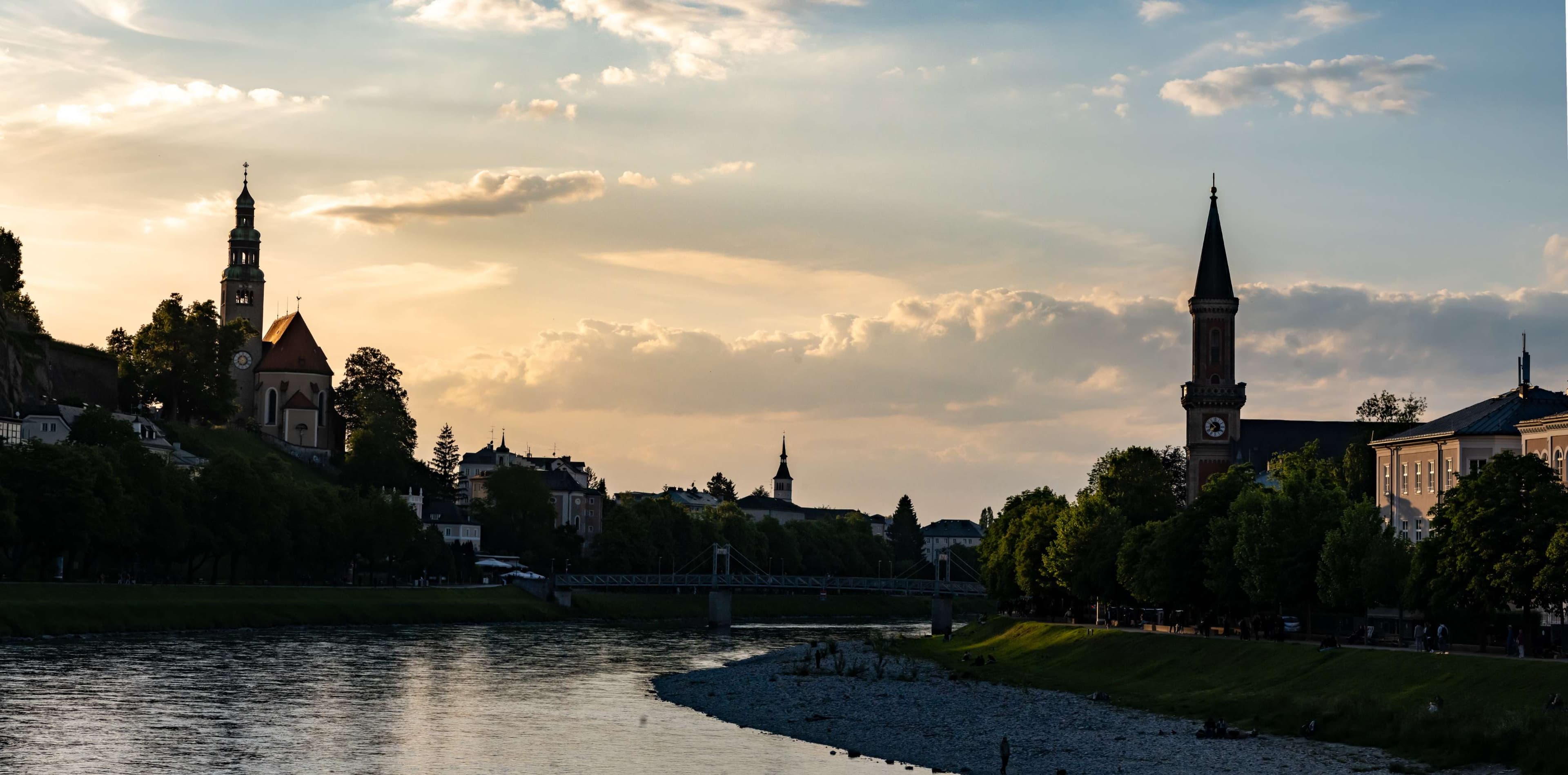 There is a river running through a city with a clock tower in the background.