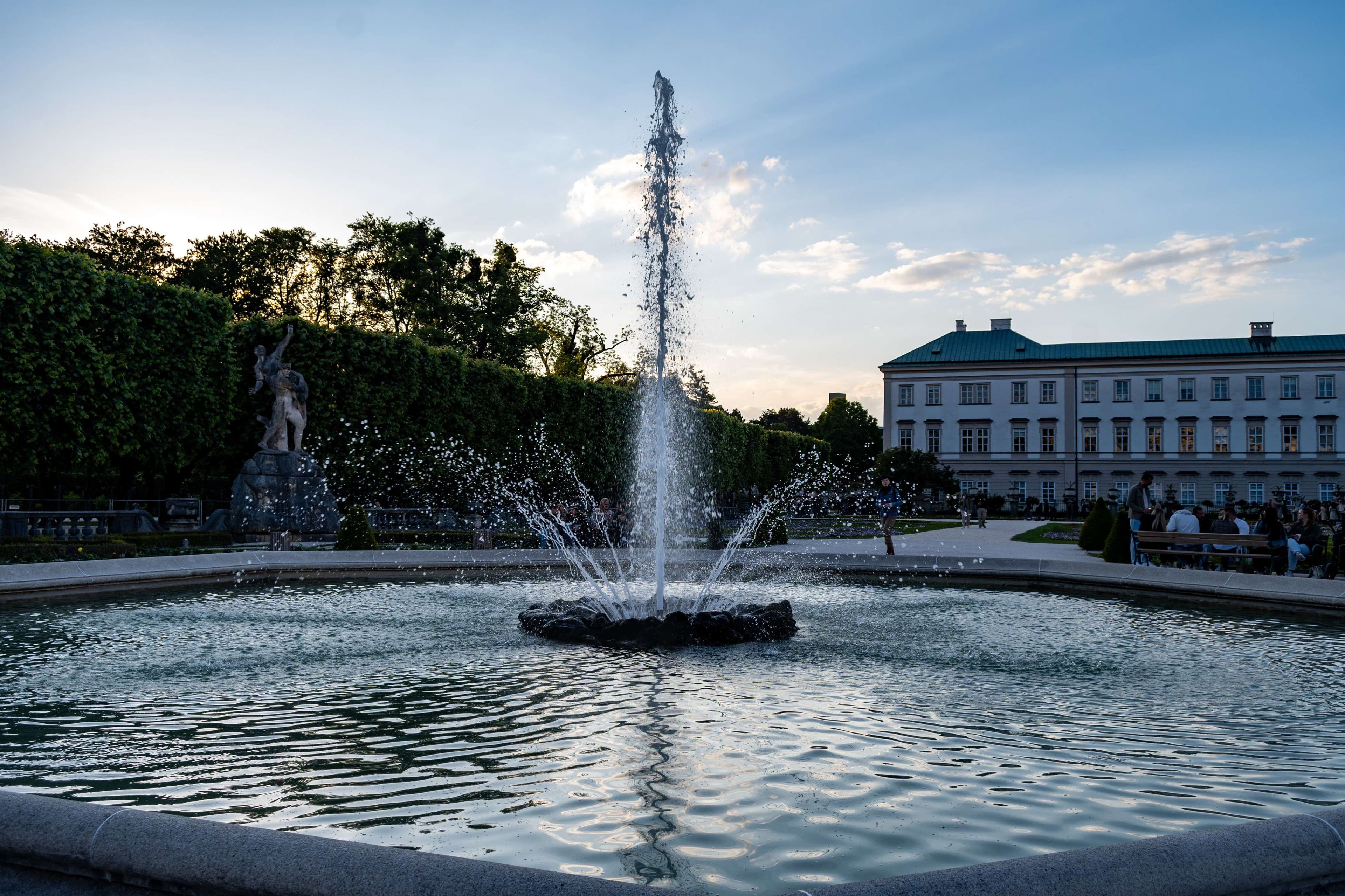 There is a fountain with water spouting out of it in a park.