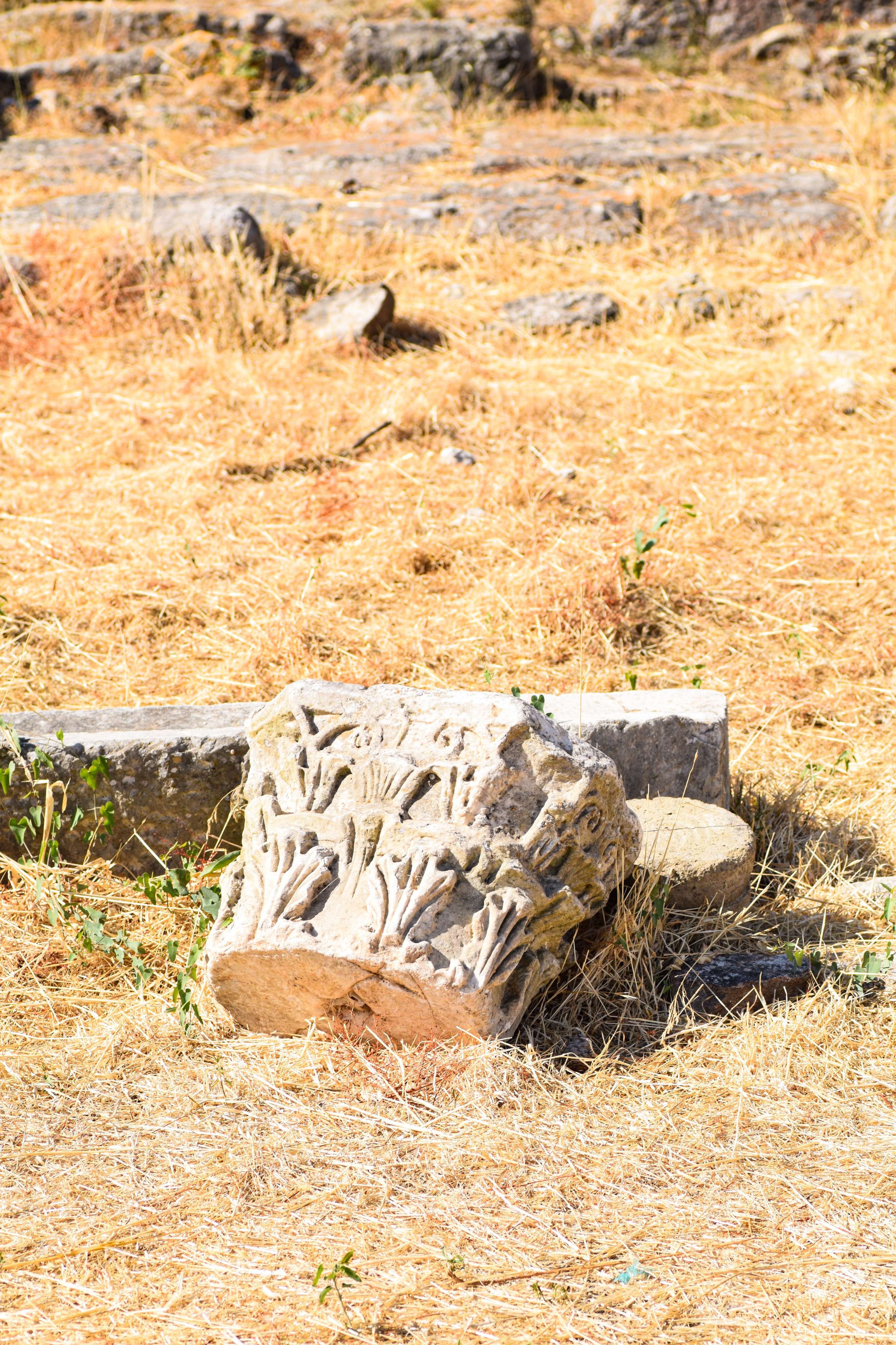 There is a stone block sitting in the middle of a field.