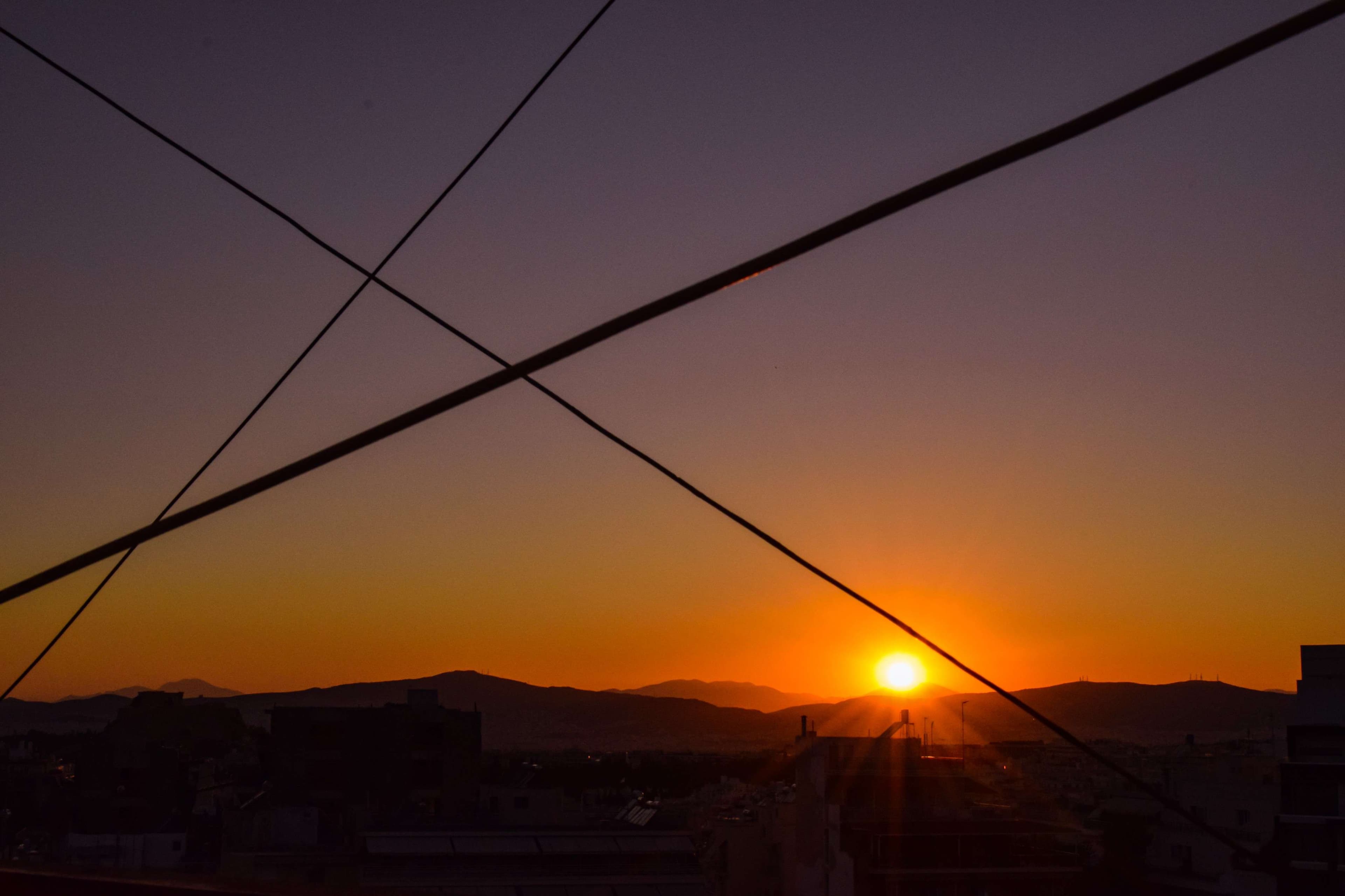 Arafed view of a sunset over a city with a train going by.