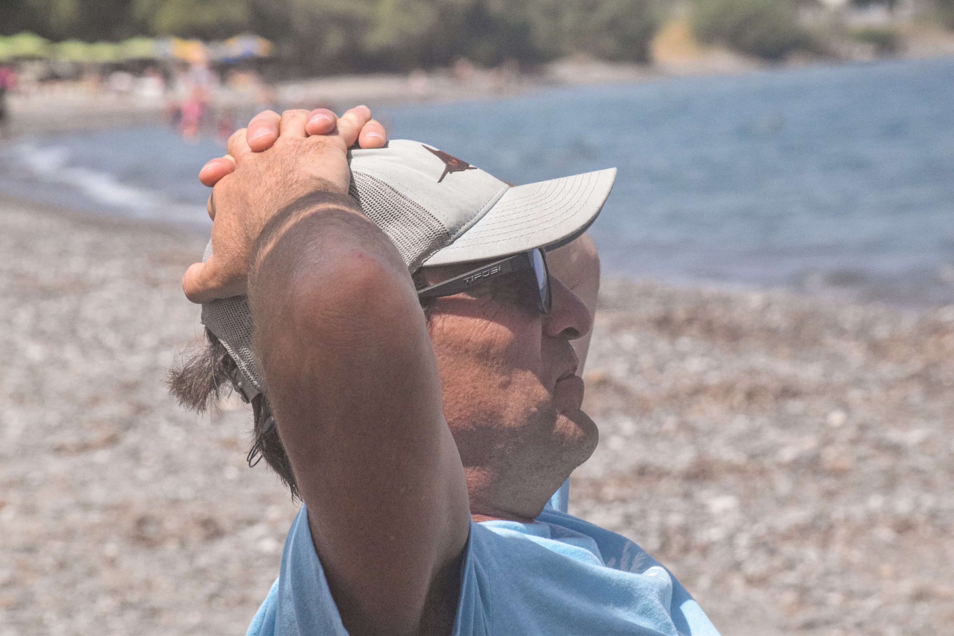 There is a man that is holding a frisbee on his head.