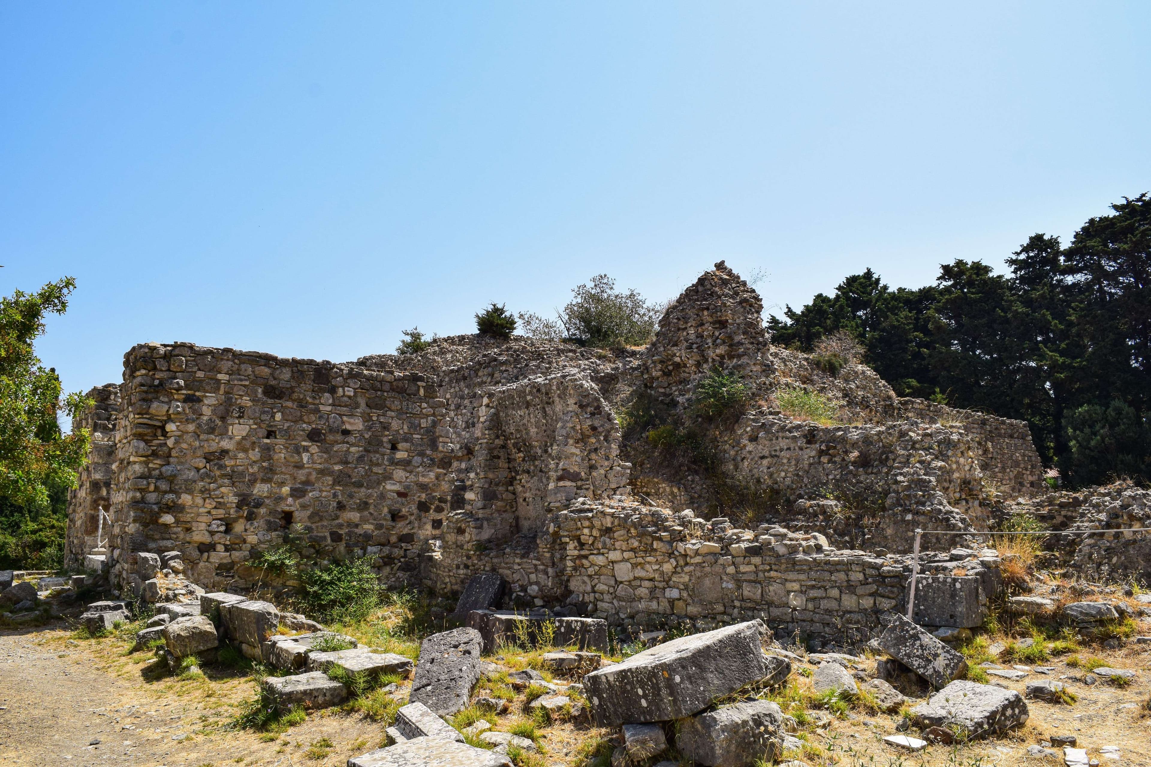 There is a stone building with a clock tower on top of it.