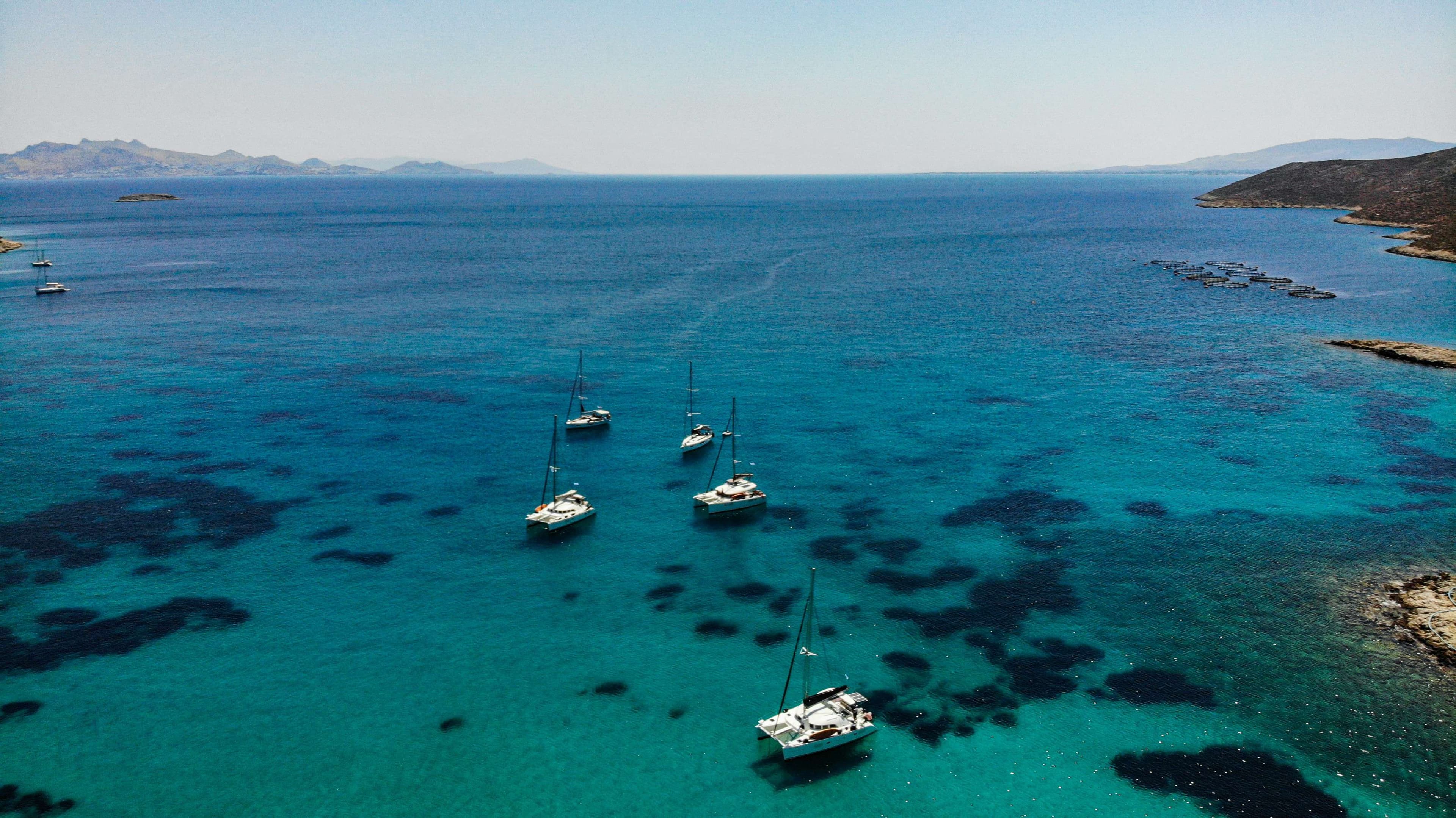 Several boats are anchored in the clear blue waters of the ocean.