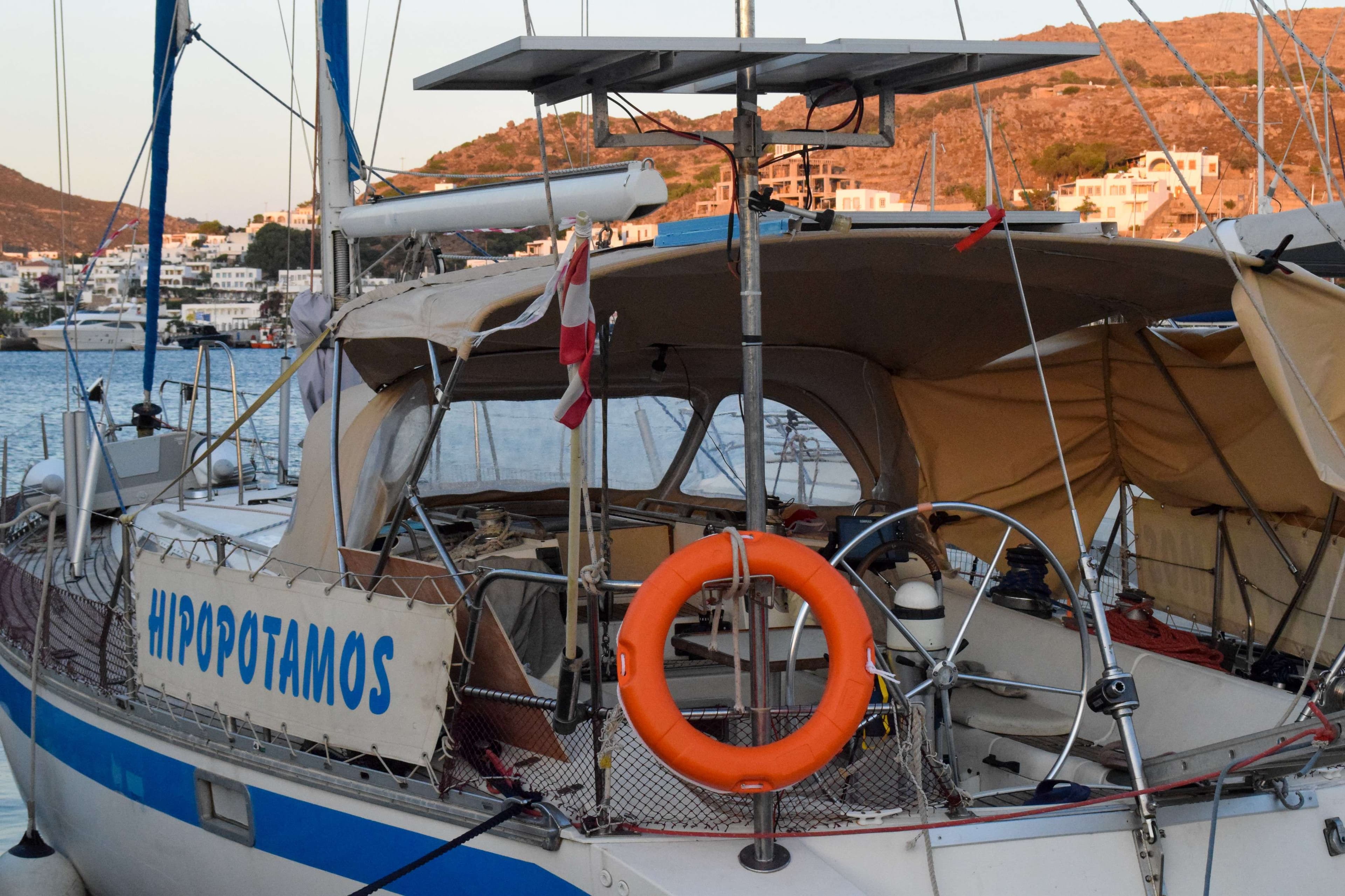 There is a red and white boat in the water near a dock.