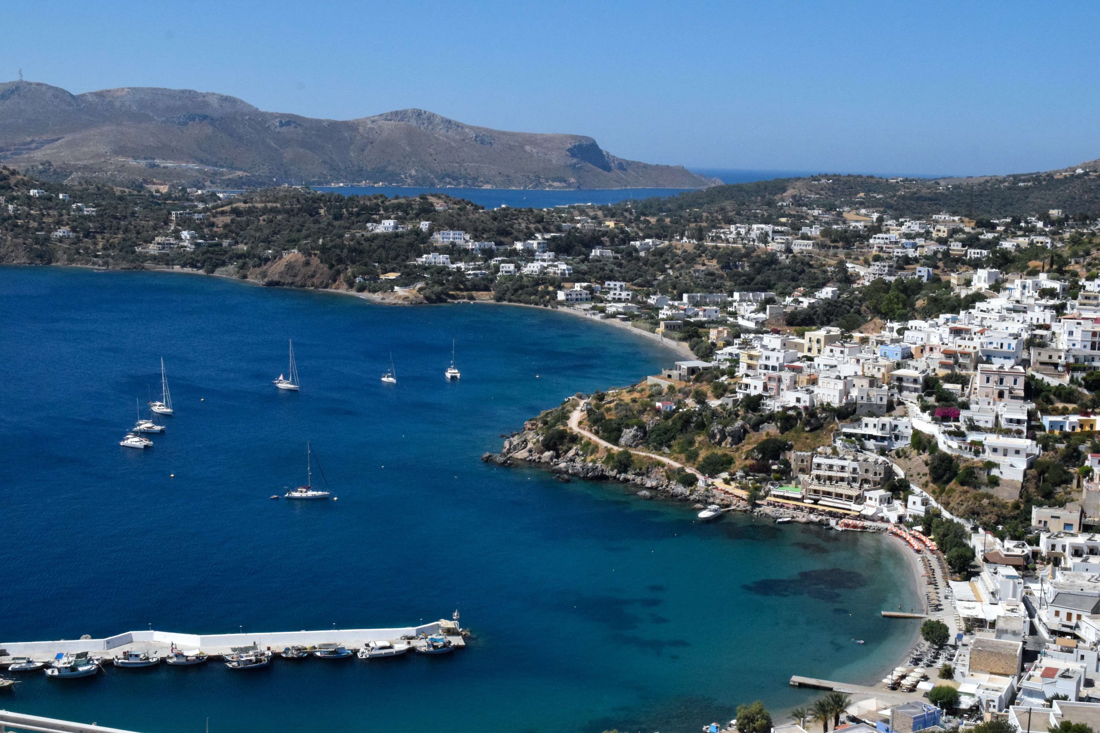 There is a boat that is floating in the water near a beach.