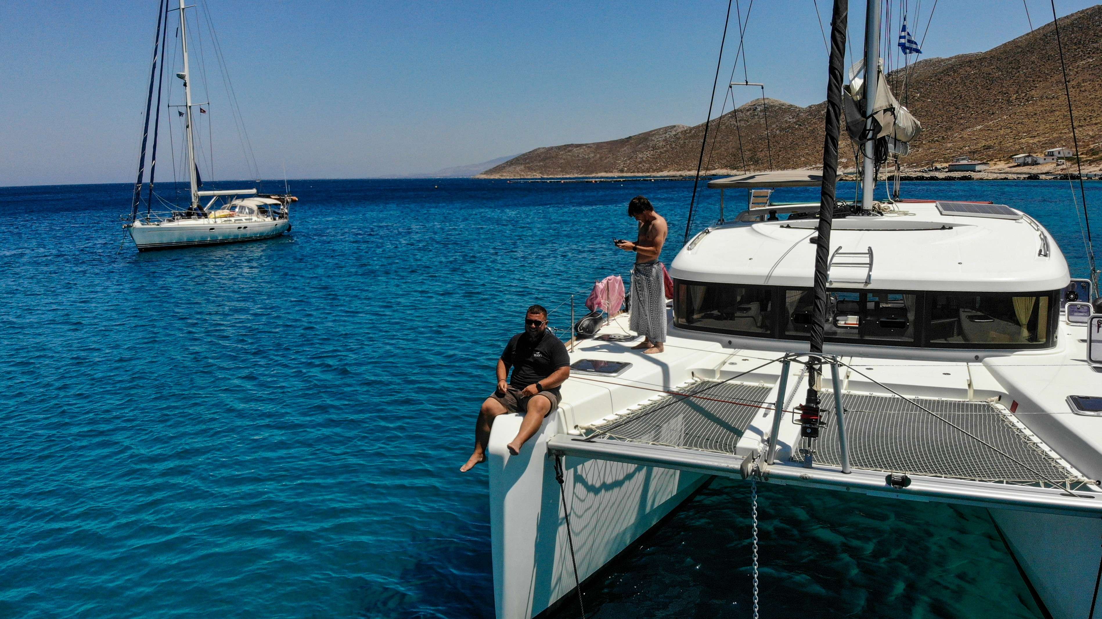 There are two people sitting on the bow of a boat.