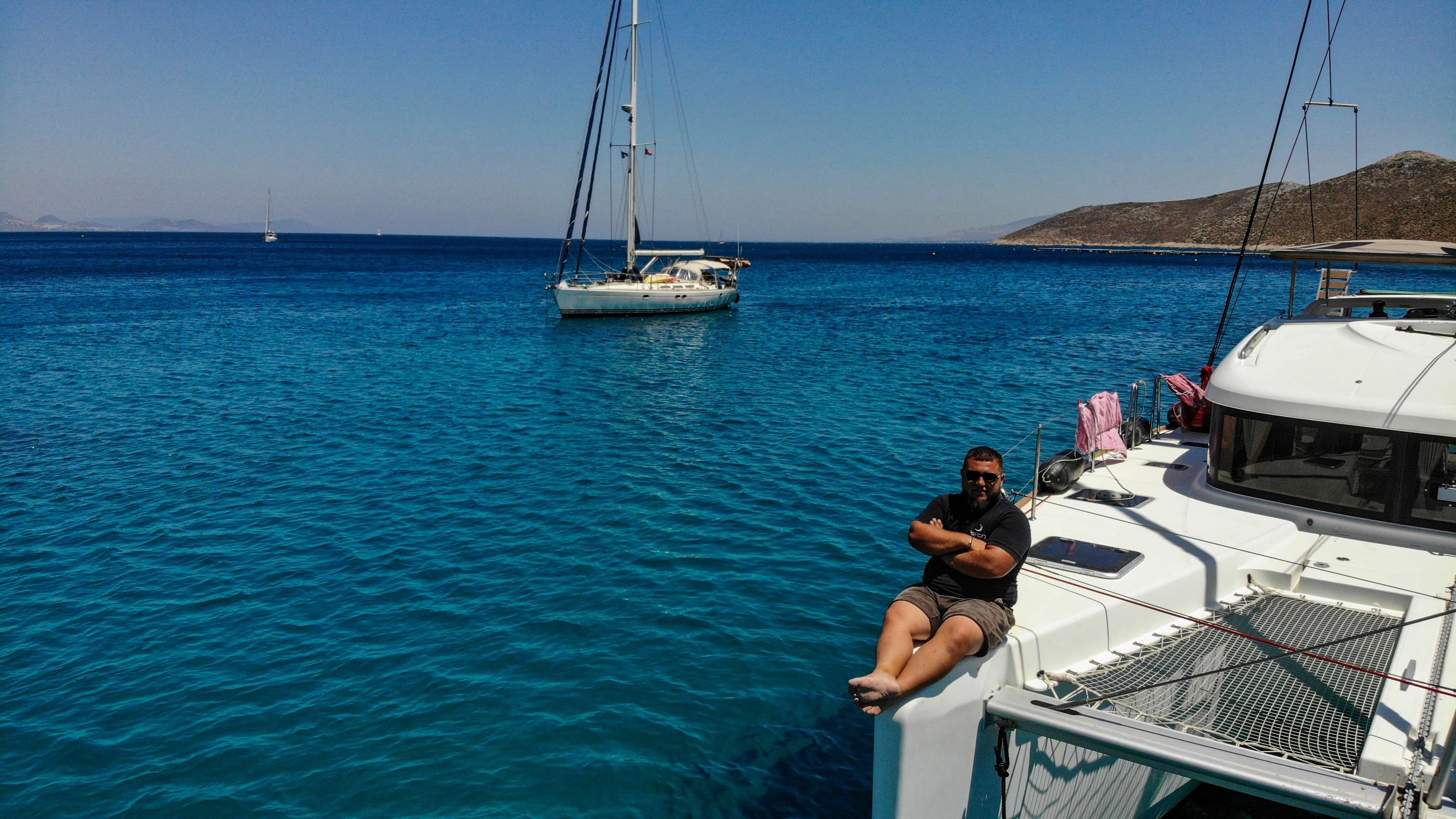 There is a man sitting on a boat in the water.