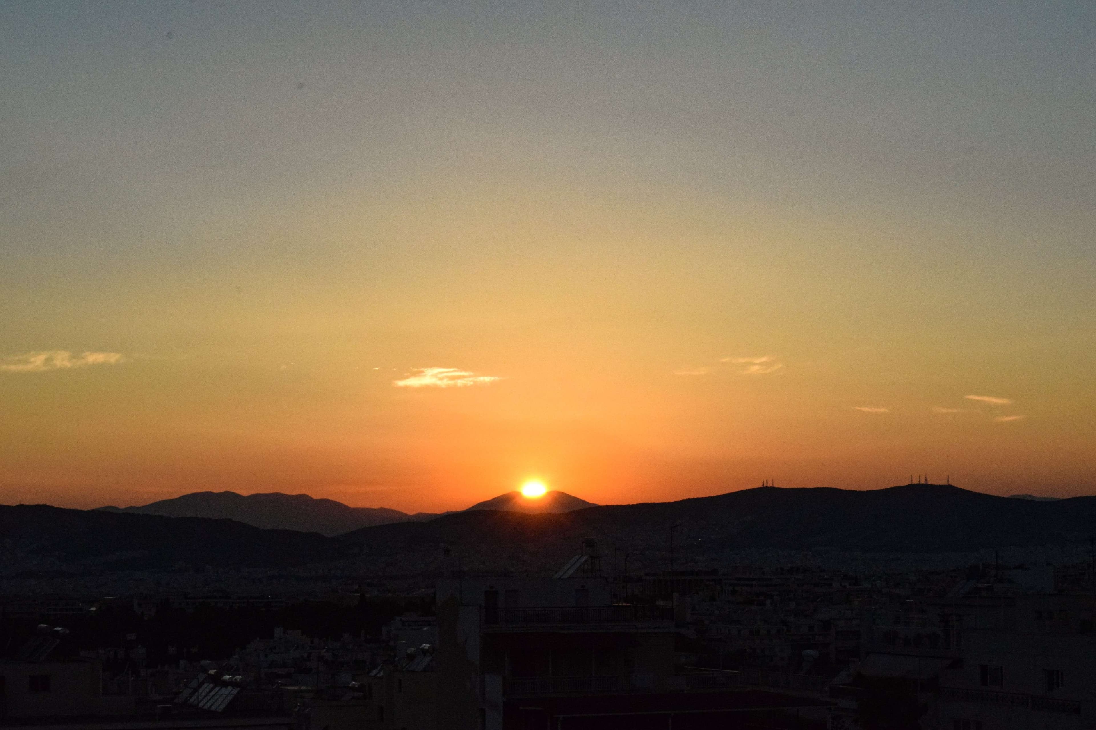 Arafed view of a sunset over a city with mountains in the background.