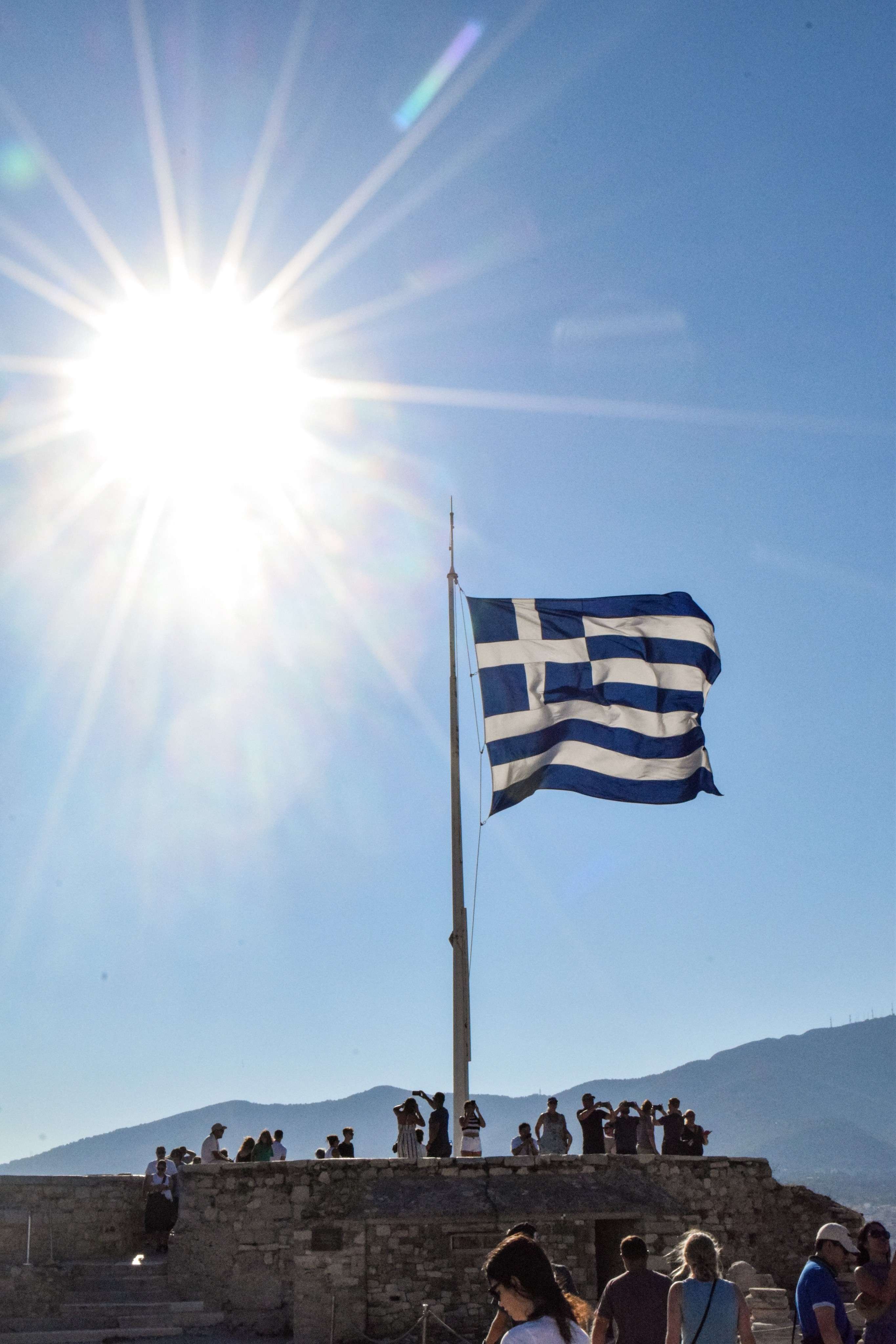People are standing on a hill with a flag flying in the air.
